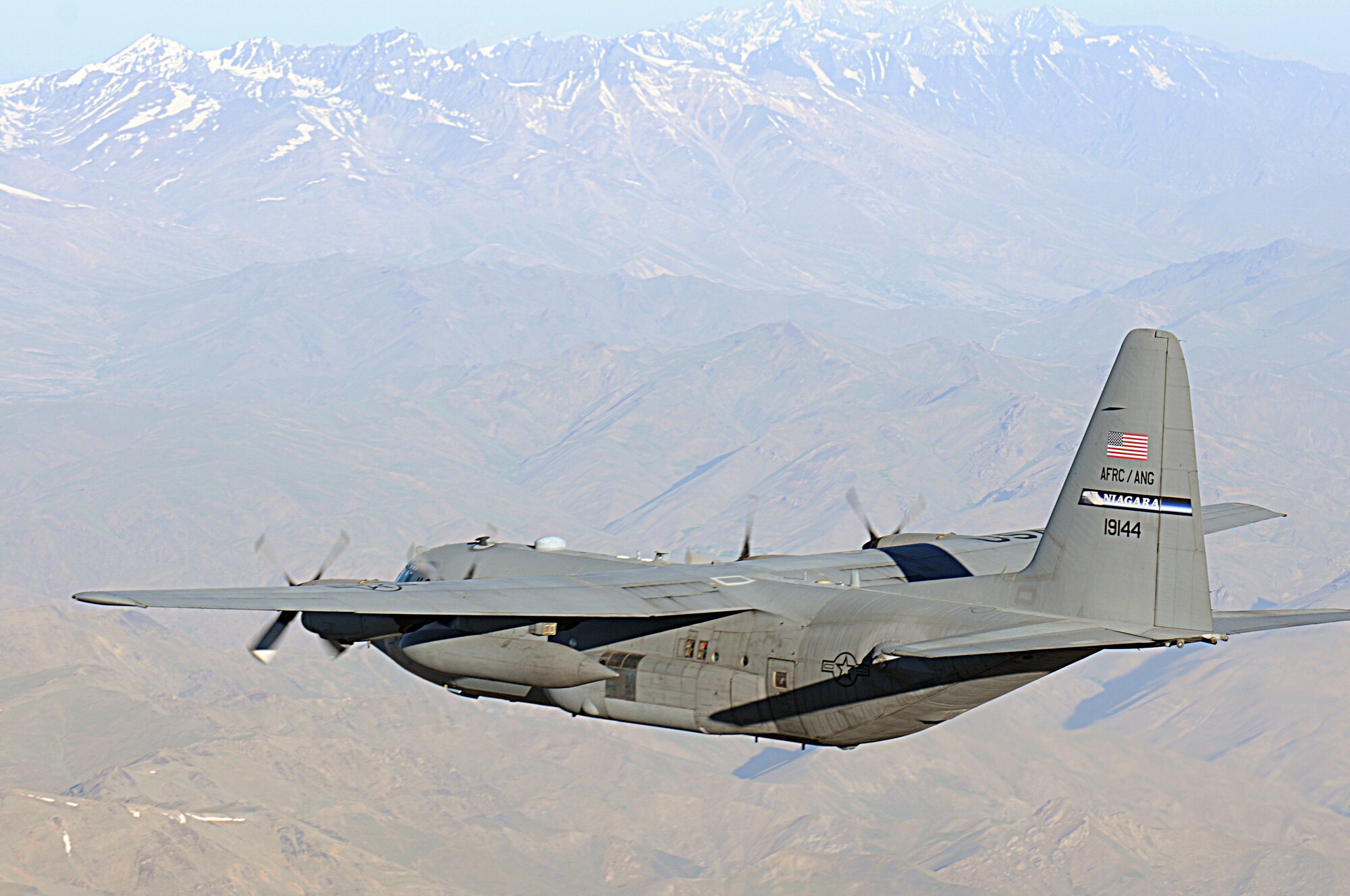 BAGRAM AIRFIELD, Afghanistan -- A C-130 Hercules from the New York Air National Guard flies over rugged Afghan landscape on its way to delivering much-needed supplies to a forward operating base in Oruzgan Province, Afghanistan, June 22. The New York ANG C-130 flew the airdrop mission in conjunction with another C-130 from the Alaska ANG. Airdrops help mitigate the danger of transporting supplies via convoy. (U.S. Air Force photo by Senior Airman Krista Rose.)