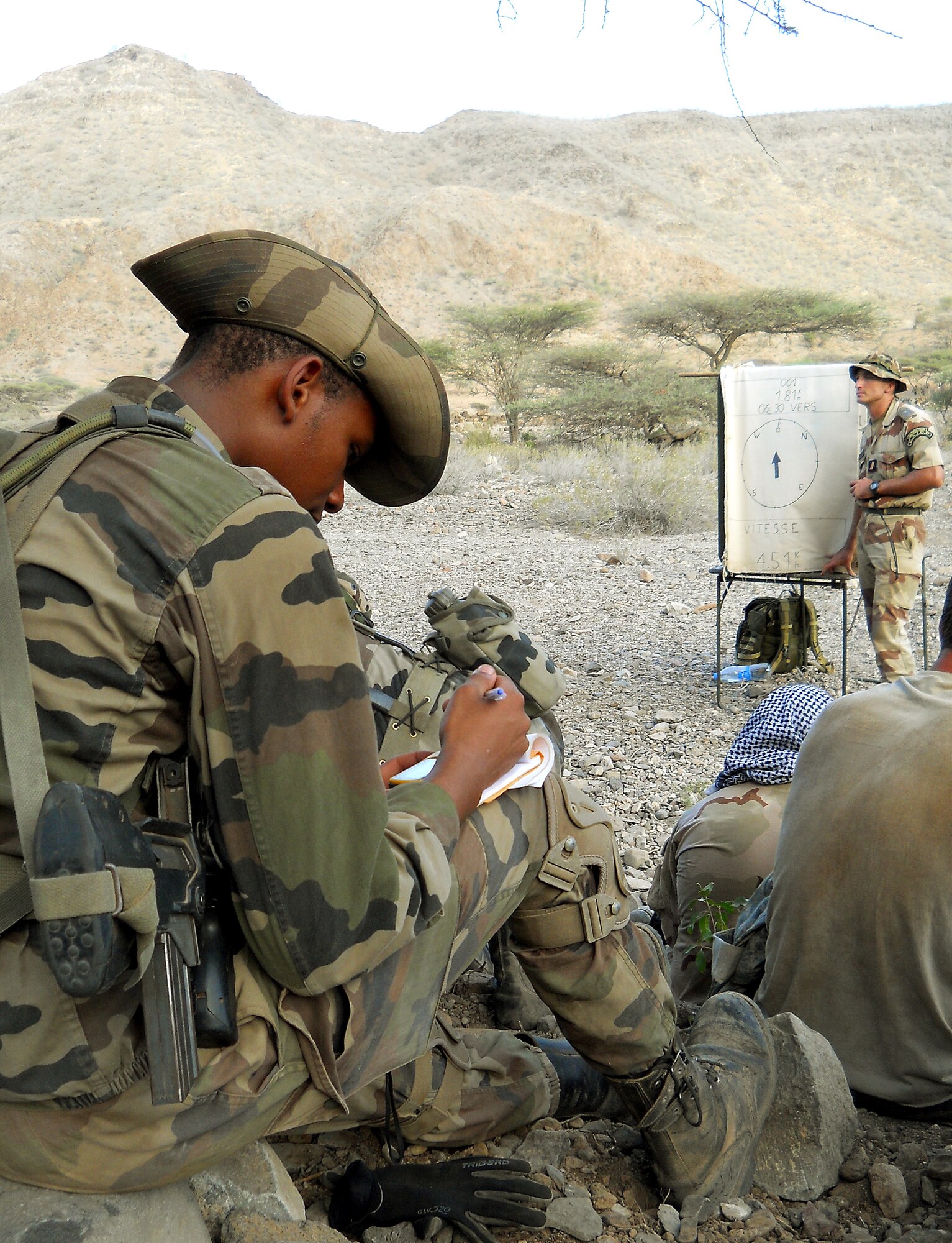 GOUBETTO, Djibouti – A French Army 5th Marine Regiment member takes notes on how to use a global positioning system device during a desert combat training course which began May 31, in the Bour Ougoul training area. The 10-day course provided nearly 120 French and 40 U.S. servicemembers with a basic knowledge of field tactics and survival techniques to be used within a desert environment. (U.S. Air Force photo by Staff Sgt. R.J. Biermann)