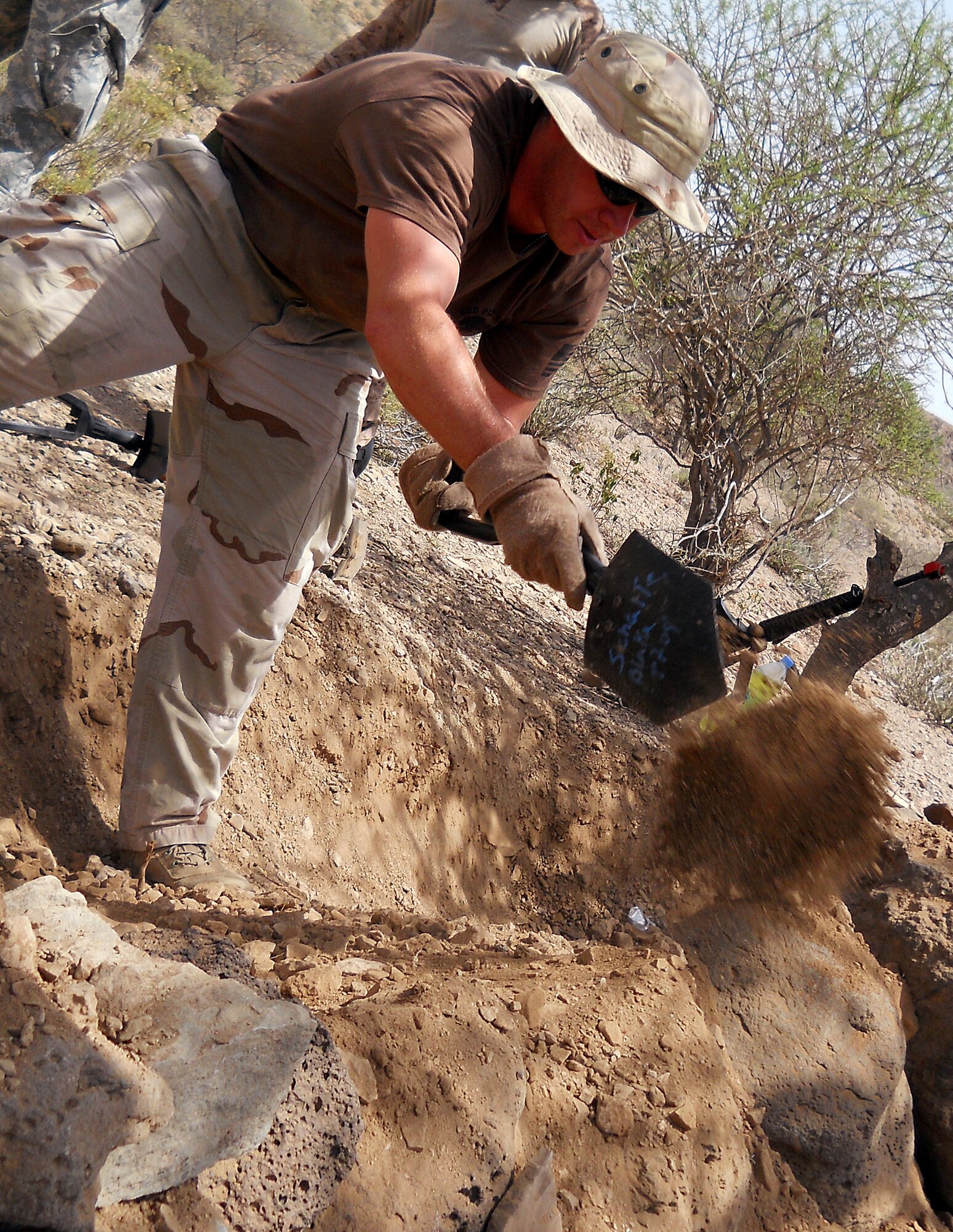 GOUBETTO, Djibouti – U.S. Navy Petty Officer 2nd Class Joe Heinicke, Combined Joint Task Force – Horn of Africa Explosive Ordnance Disposal technician, digs a security trench in the Bour Ougoul training area May 31, during the French Army 5th Marine Regiment Desert Combat Training. The 10-day course provided nearly 120 French and 40 U.S. servicemembers with a basic knowledge of field tactics and survival techniques to use within a desert environment. (U.S. Air Force photo by Staff Sgt. R.J. Biermann) 