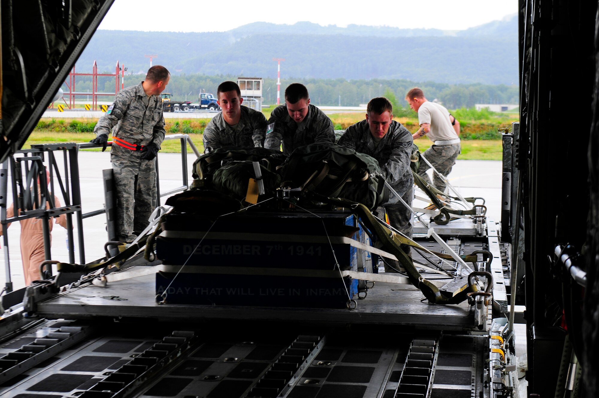 U.S. Air Force personnel from the 86th Logistics Readiness Squadron load cargo on a C130-J Super Hercules from Marine Corps Air Station Cherry Point, North Carolina at Ramstein Air Base, Germany, June 22, 2011. The 86th LRS aerial delivery section partnered with the 86th Operations Support Squadron joint airdrop inspectors and the 37th Airlift Squadron central scheduling team to provide simultaneous, logistical planning and support to sustain airdrop training for the Marine Aerial Refueler Transport Squadron 252 Marine Corps unit. While performing three concurrent operations, the aerial delivery personnel rigged and loaded 20 short tons of airdrop training and real world assets, to include two HMMWV 5th Quarter Masters to support local brigade training. (U.S. Air Force Photo by Airman 1st Class Brea Miller)