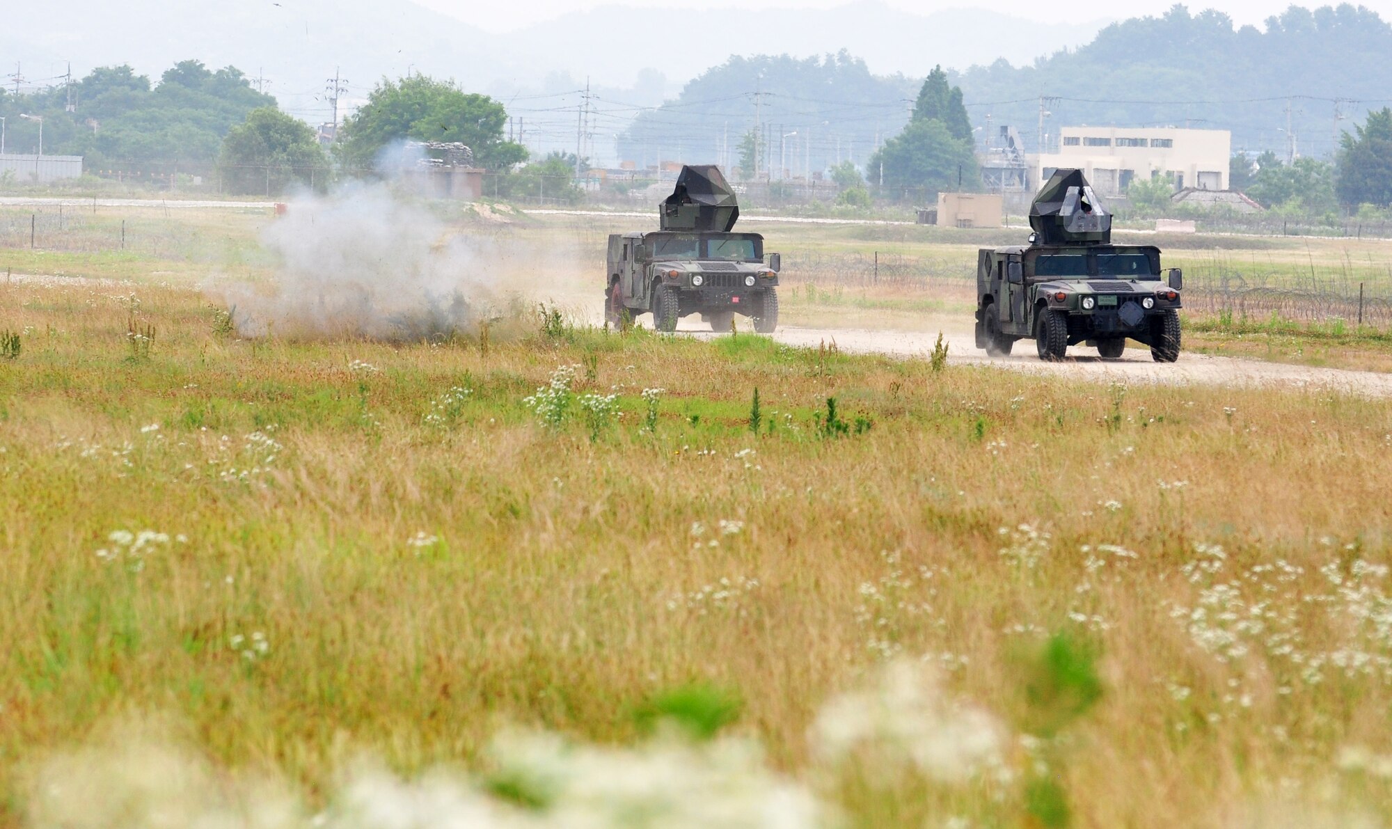 A simulated improvised explosive device (IED) goes off as a convoy passes during tactical convoy training. Approximately 150 Airmen from the 51st Civil Engineer Squadron participated in PRIME BEEF training June 22 at Osan. Prime BEEF forces have the necessary command, control and communications to support beddown; fire emergency services; emergency management; explosive ordnance disposal; expedient construction; explosive incident response; chemical, biological, radiological and nuclear response and other specialized mission areas. (U.S. Air Force photo/Staff Sgt. Chad Thompson)