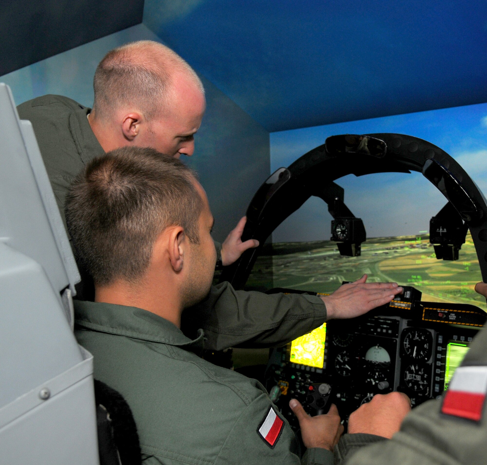 SPANGDAHLEM AIR BASE, Germany – Capt. John Cotman, 81st Fighter Squadron A-10 Thunderbolt II pilot, explains to Polish air force 1st Lt. Karol Hali how the A-10 Thunderbolt II simulator works here June 21. Poland’s air force visited the 52nd Fighter Wing to build community relations and learn about the base’s daily flight support operations. (U.S. Air Force photo/Airman 1st Class Dillon Davis)