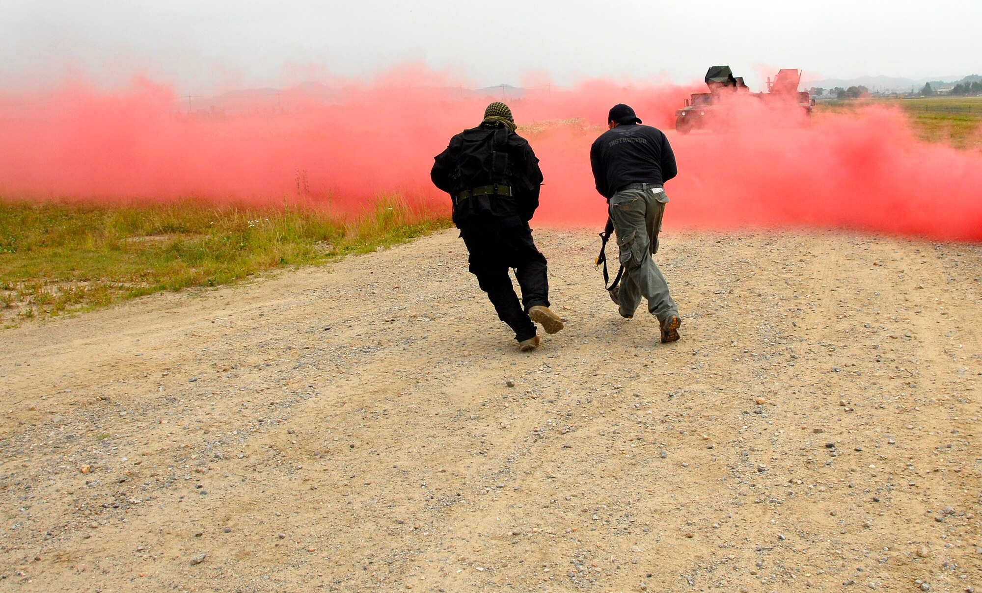 Opposition force (OPFOR) members Airman 1st Class Destry Swadowski, left, and Tech. Sgt. Christopher Clark “attack” a convoy of Humvees June 22 at Osan Air Base, Republic of Korea. Approximately 150 Airmen from the 51st Civil Engineer Squadron participated in PRIME BEEF training. Prime BEEF forces have the necessary command, control and communications to support beddown; fire emergency services; emergency management; explosive ordnance disposal; expedient construction; explosive incident response; chemical, biological, radiological and nuclear response and other specialized mission areas. (U.S. Air Force photo/Senior Master Sgt. Paul Holcomb)