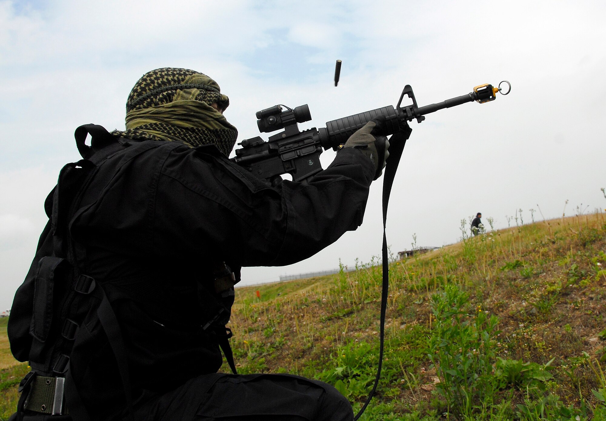 Opposition force (OPFOR) member Airman 1st Class Destry Swadowski, an emergency management technician assigned to the 51st Civil Engineer Squadron, Osan Air Base, Republic of Korea, fires blanks from his M-4 rifle toward a convoy of Humvees June 22 at Osan Air Base, Republic of Korea. Approximately 150 Airmen from the 51st Civil Engineer Squadron participated in PRIME BEEF training. Prime BEEF forces have the necessary command, control and communications to support beddown; fire emergency services; emergency management; explosive ordnance disposal; expedient construction; explosive incident response; chemical, biological, radiological and nuclear response and other specialized mission areas. (U.S. Air Force photo/Senior Master Sgt. Paul Holcomb)