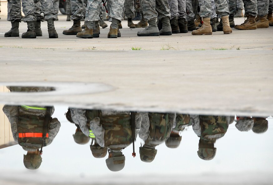 Airmen assigned to the 51st Civil Engineer Squadron, Osan Air Base, Republic of Korea, are reflected in a puddle while awaiting the start of convoy operations classroom training. Approximately 150 Airmen from the 51st Civil Engineer Squadron participated in PRIME BEEF training June 22 at Osan. Prime BEEF forces have the necessary command, control and communications to support beddown; fire emergency services; emergency management; explosive ordnance disposal; expedient construction; explosive incident response; chemical, biological, radiological and nuclear response and other specialized mission areas.
 (U.S. Air Force photo/Senior Master Sgt. Paul Holcomb)