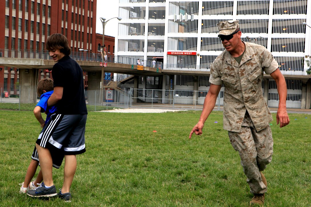 Lance Cpl. Rudy Basaldua, a machine gun team leader with 3rd Battalion, 24th Marine Regiment, directs Trevor Erickson, 13, a native of St. Louis, in the buddy drag portion of the Combat Fitness Test June 23, 2011. Locals were invited to participate in the CFT as part of Marine Week St. Louis activities.