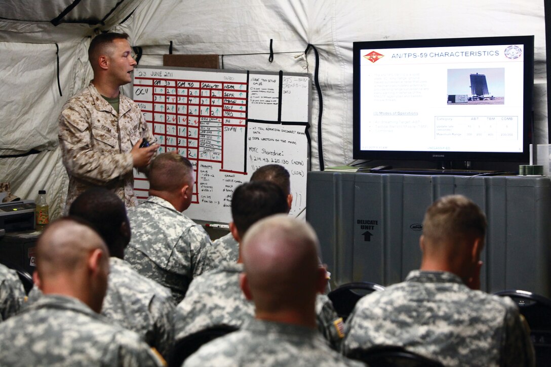 Susan A. Randolph (right facing forward) uses American Sign Language to interpret the words of the National Anthem during the Maintenance Center Barstow change of command ceremony for a group of Deaf employees June 23. Linda A. Hardy (left) looks on, ready to take over for her fellow Signer during the event aboard Marine Corps Logistics Base Barstow.