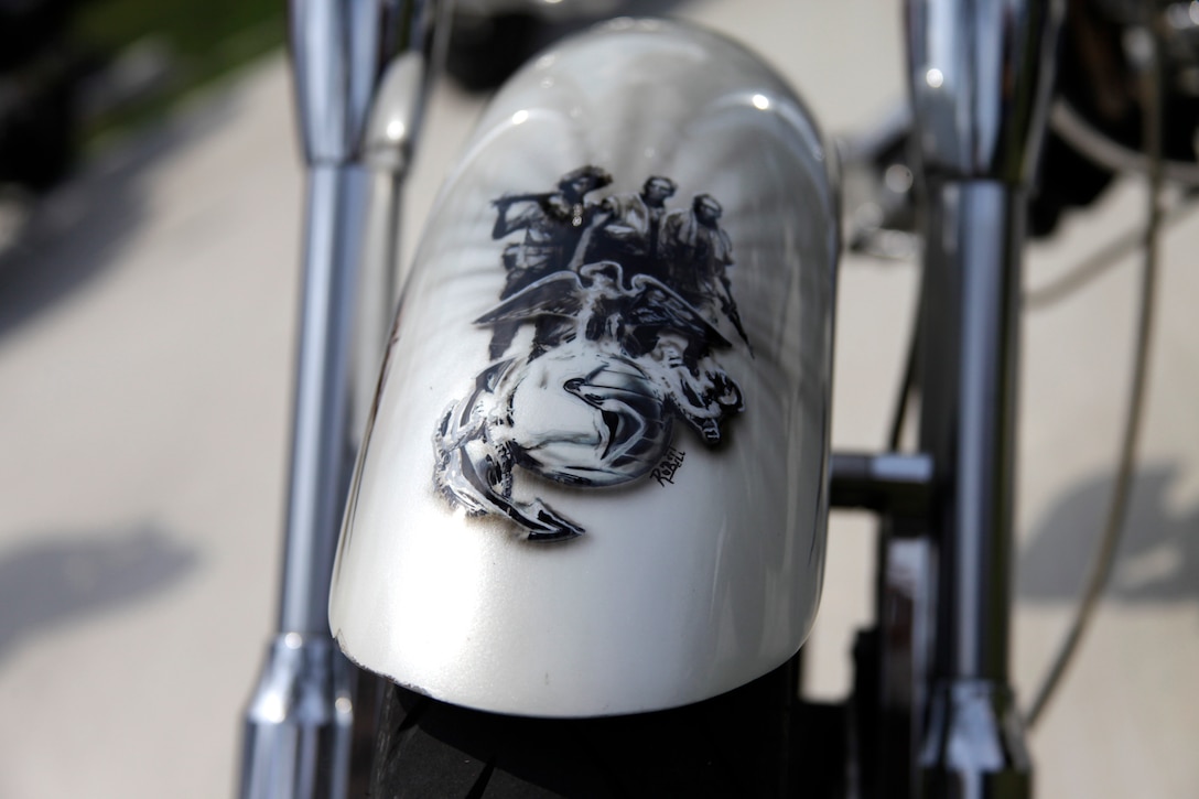 The front fender of Gunnery Sgt. Brendan K. Malyk’s Cadillac Pearl-colored, shovelhead style-framed, custom built motorcycle shimmers with Marine Corps-inspired artwork on its tank and fenders. Malyk, a radio maintenance chief with Marine Wing Communications Squadron 28, and more than 200 other motorcyclists rode their bikes out Cherry Point’s Miller’s Landing for the air station’s inaugural Marine Corps Community Services Biker Bash June 24.