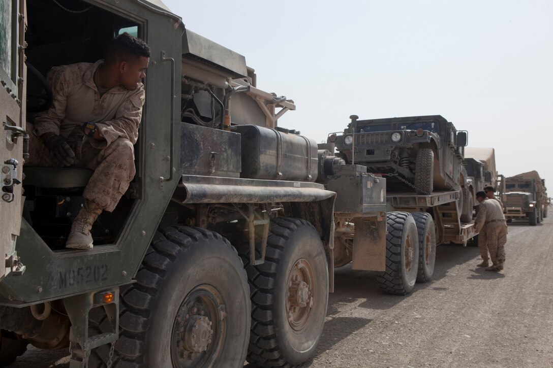 Master Sgt. Enmanuel Tejada (left), the convoy commander with Marine Wing Support Squadron 272, waits as Marines inspect an MK48 Logistics Vehicle System's flatbed prior to unloading gear belonging to Marine Unmanned Aerial Vehicle Squadron 3 on Camp Leatherneck, Afghanistan, June 24. MWSS-272 partnered with Combat Logistics Battalion 7, transported gear for VMU-3 from Camp Dwyer to the squadrons new location at Camp Leatherneck.