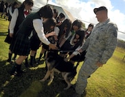 Staff Sgt. Johnathan Bielke, military working dog handler, allows high school students from Sendai Japan to pet a military working dog June 24. The students are from Sendai Ikuei Gakuen High School and are continuing their education in Hawaii while their homes and school are being rebuilt in Sendai, Japan. The students came to Joint Base Pearl Harbor-Hickam to tour the base and meet the C-17 Globemaster III crew who flew to Sendai following the earthquake and tsunami. (U.S. Air Force photo/Senior Airman Lauren Main)