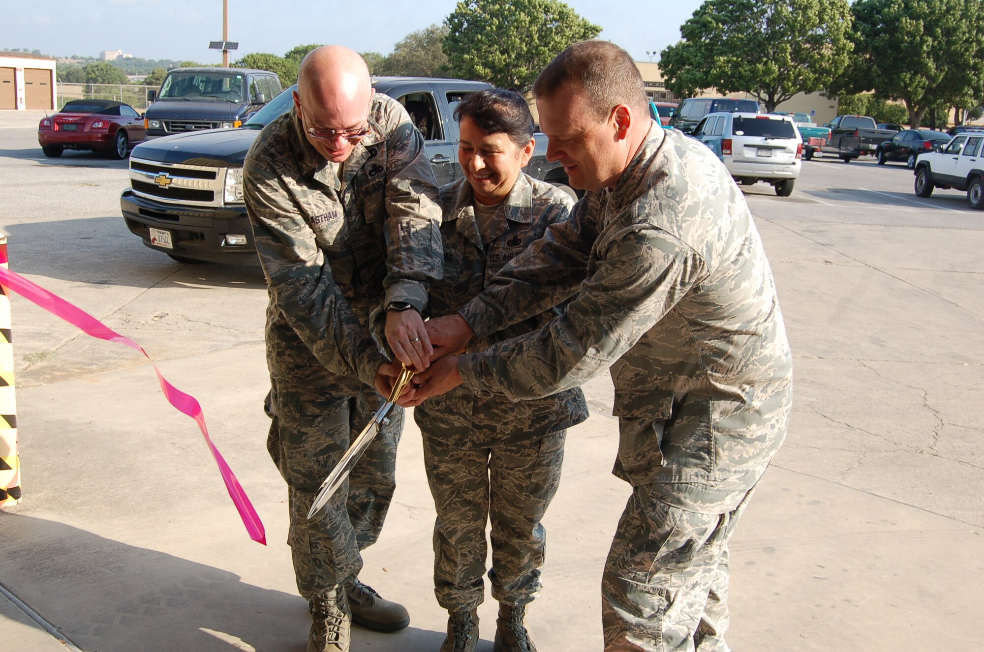 Maj. David Eastham, 433rd Logistics Readiness Squadron commander; Senior Master Sgt. Julia Valderas, Maintenance Support section supervisor; and Col. Craig Petersen, 433rd Mission Support Group commander, cut the ribbon to the renovated maintenance support section facility at the 433rd Airlift Wing, June 17, 2011.  The renovated building is located closer to the wing's maintenance facilities and makes for greater efficiency for maintenance workers to get needed C-5 Galaxy parts and tools. (U.S. Air Force photo/Elsa Martinez)