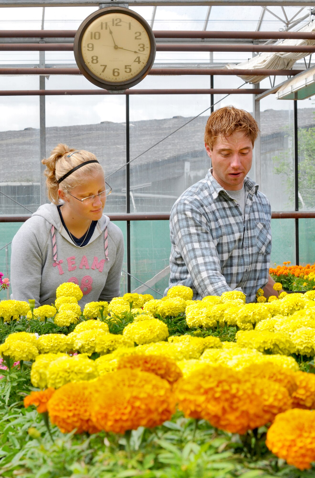 Gardeners Julia Baustert and Christian Mueller tend to flowers June 14, 2011, at the Spangdahlem Air Base, Germany, greenhouse located on the Bitburg Annex. By planting and growing more than 35,000 flowers a year, gardeners with the 52nd Civil Engineer Squadron annually save the Air Force approximately 50,000 Euro. They maintain more than 45 different species of flowers throughout the year. (U.S. Air Force photo/Senior Airman Nick Wilson)