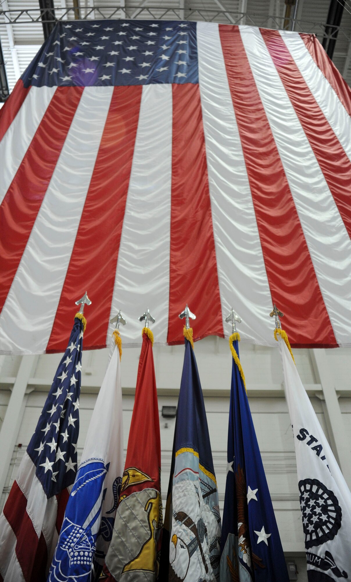 Flags stand ready at the 87th Air Base Wing change of command ceremony June 24 in Hangar 2201 at Joint Base McGuire-Dix-Lakehurst. During the event Brig. Gen. Gina M. Grosso relinquished command to Col. John M. Wood. (U.S. Air Force photo by 2nd Lt. David J. Murphy/Released)