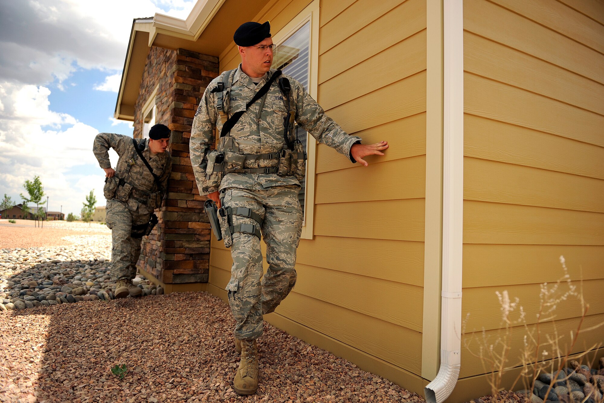 Staff Sgts. Garrett Engle and Nathan Pritz arrive in base housing to respond to a report of domestic violence during an exercise June 15, 2011, at Schriever Air Force Base, Colo. Sergeants Engle and Pritz are  members of the 50th Security Forces Squadron. (U.S. Air Force photo/Dennis Rogers)
