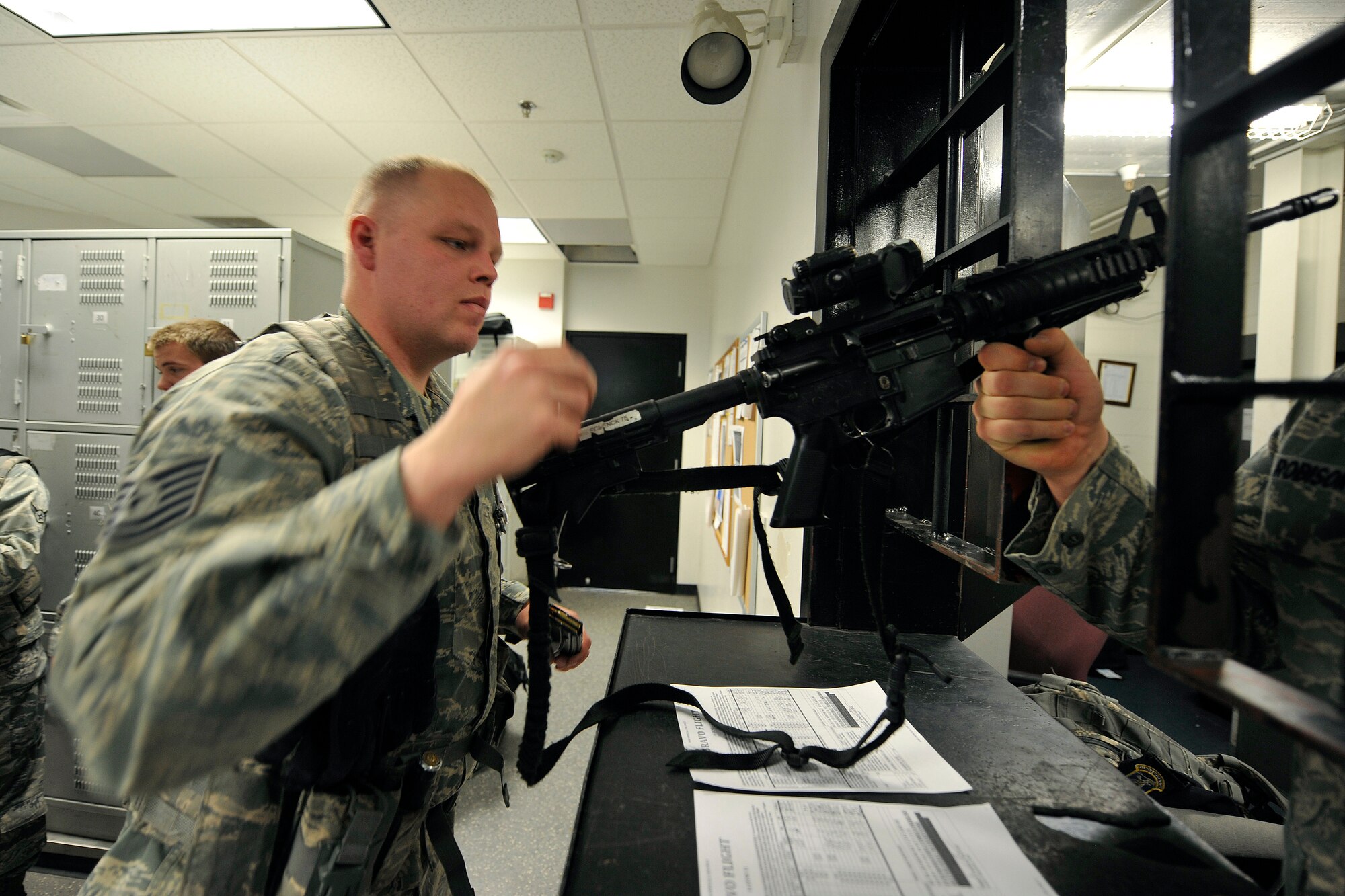 Tech. Sgt. Conrad Schenck arms up as he begins his shift during guard mount at the base armory June 15, 2011, at Schriever Air Force Base, Colo. Sergeant Schenck is a member of the 50th Security Forces Squadron. (U.S. Air Force photo/Dennis Rogers)
