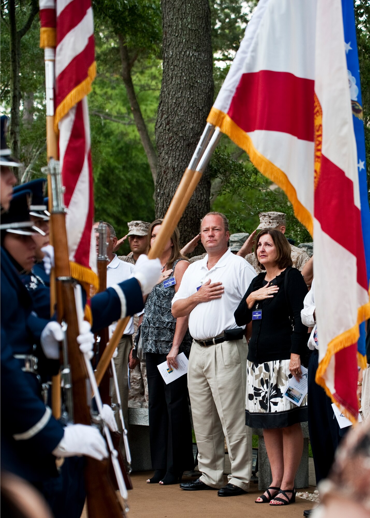 Jeff Marthaler, uncle of Airman 1st Class Brent Marthaler, and Bridget Brooks, mother of Airman 1st Class Joseph Rimkus, watch as the colors are presented at the Khobar Towers Memorial ceremony June 24 at Eglin Air Force Base, Fla.  June 25 marks the 15th anniversary of the tragic bombing that killed 19 service members including 12 33rd FW Airmen.  Each year, a ceremony is held by the Nomads to commemorate their brothers who’ve “ceased their wandering.”  (U.S. Air Force photo/Samuel King Jr.)