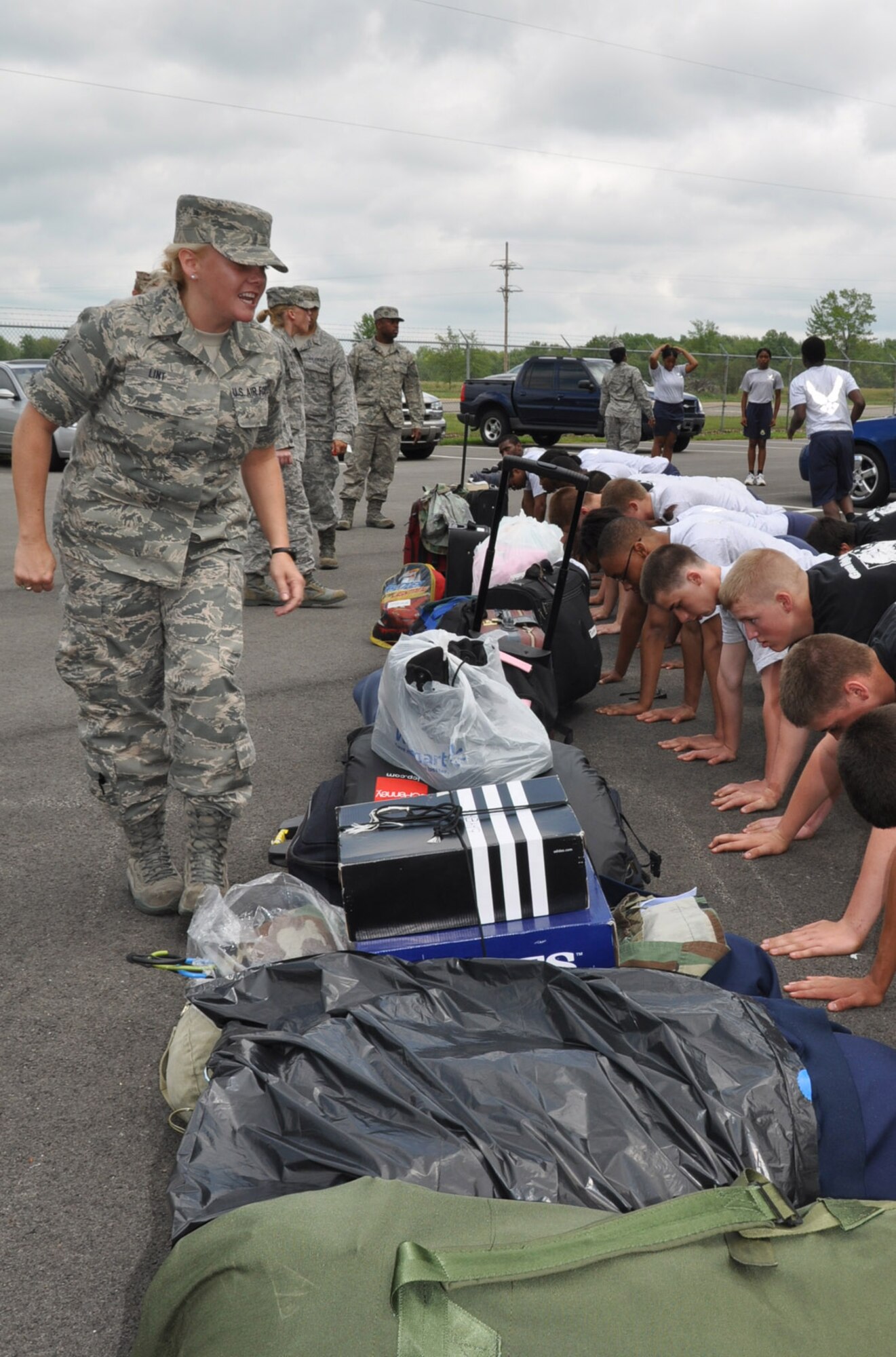 YOUNGSTOWN AIR RESERVE STATION, Ohio -- Air Force Reserve Senior Airman Kalee Link, a personnel specialist with the 910th Maintenance Group, closely watches Air Force Junior Reserve Officer Training Corps (AFJROTC) cadets demonstrates push-ups during the annual encampment here June 22.   The 910th Airlift Wing here is hosting approximately 50 JROTC cadets from Ohio high schools for a 5-day encampment June 22-26. The cadets are ninth through 12th grade students at John Marshall and East Technical High Schools in Cleveland; Green High School in Uniontown; and Trumbull Career and Technical Center in Warren. Approximately 19 Youngstown Air Reserve Station Sailors, Marines and Airmen volunteered to teach the youth leadership, teamwork, respect for others, and the Air Force core values through mentorship training, workshops, physical fitness, and drill and ceremony exercises.   The encampment concludes June 26 with a graduation ceremony. U.S. Air Force photo by Maj. Brent J. Davis