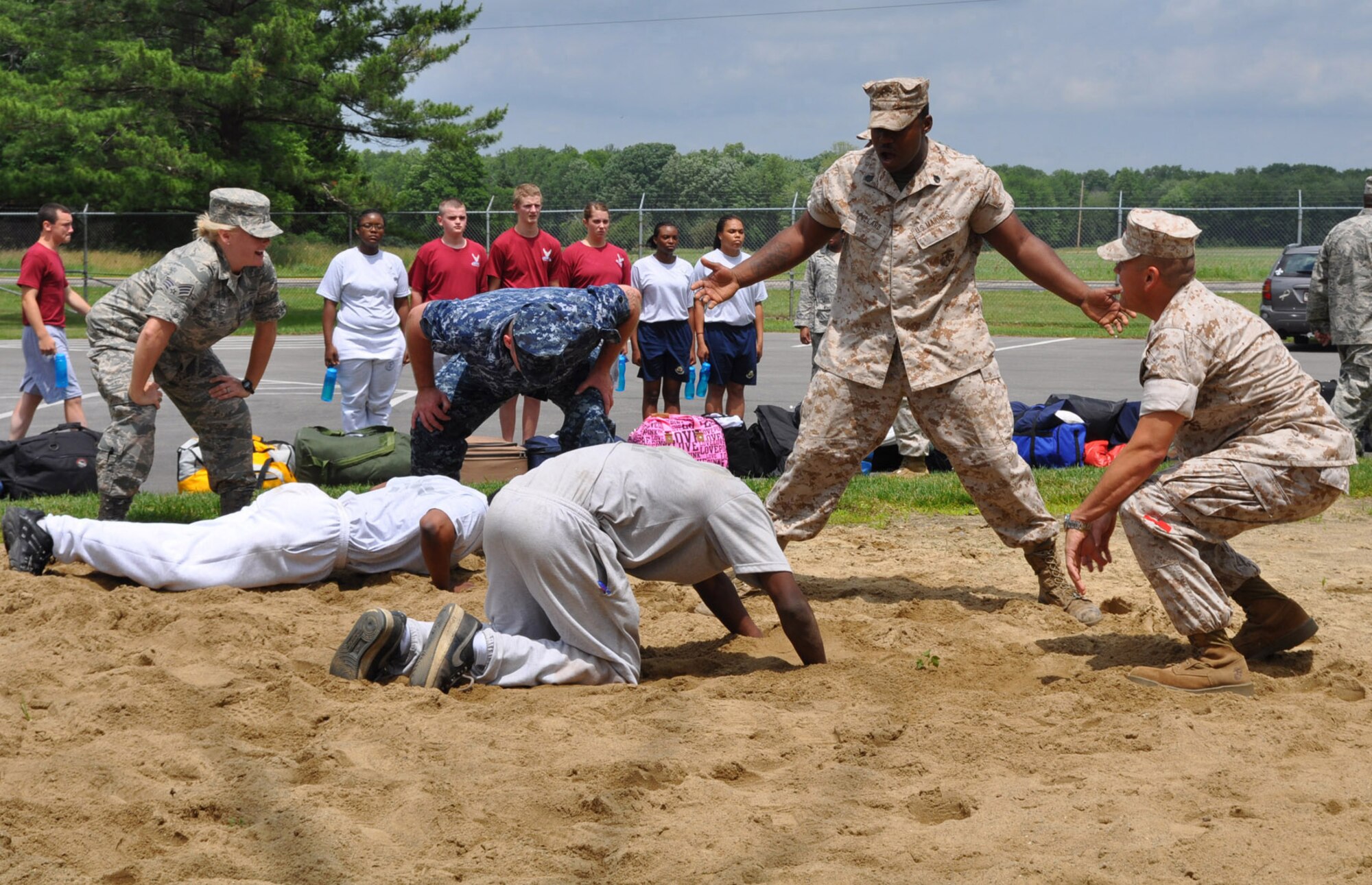 YOUNGSTOWN AIR RESERVE STATION, Ohio -- Air Force Reserve Senior Airman Kalee Link, Navy Boatswain's Mate 2 Jerid O'Brien and Marine Staff Sgt. Nkrumah Pollard team up to instill motivation and discipline into Air Force Junior Reserve Officer Training Corps (AFJROTC) cadets during the annual encampment June 22.   The 910th Airlift Wing here is hosting approximately 50 JROTC cadets from Ohio high schools for a 5-day encampment June 22-26. The cadets are ninth through 12th grade students at John Marshall and East Technical High Schools in Cleveland; Green High School in Uniontown; and Trumbull Career and Technical Center in Warren. Approximately 19 Youngstown Air Reserve Station Sailors, Marines and Airmen l volunteered to teach the youth leadership, teamwork, respect for others, and the Air Force core values through mentorship training, workshops, physical fitness, and drill and ceremony exercises.   The encampment concludes June 26 with a graduation ceremony. U.S. Air Force photo by Maj. Brent J. Davis