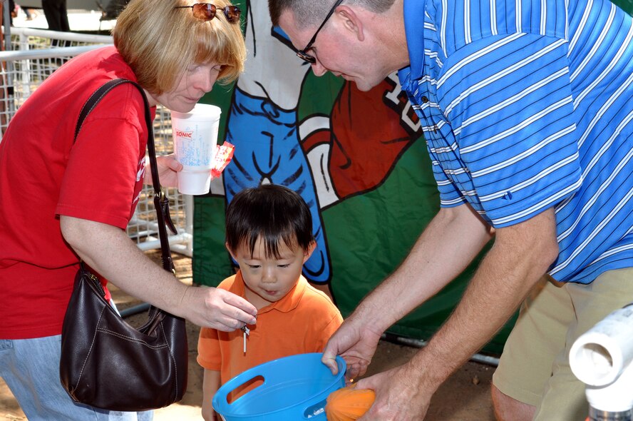 Tech. Sgt. James Parish, 301st  Maintenance Squadron, and his wife Marcy help  their son, Alex, 3, choose a prize after he participated in one of the children's games at the 301st  Fighter Wing Family Day June 4. (U.S. Air Force photo/Staff Sgt. Chris Bolen)
