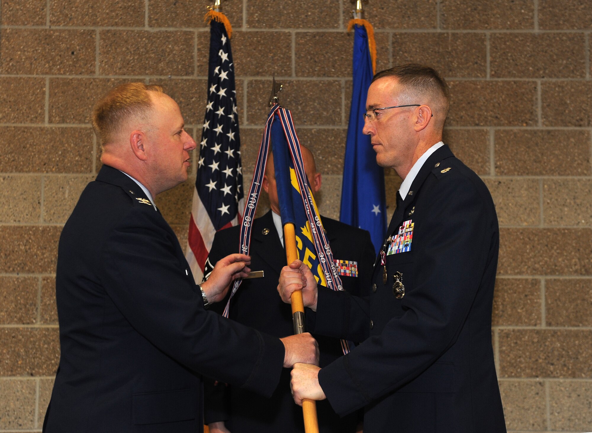 Air Force Lt. Col. Brian A. Barthel, (right) 55th Security Forces Squadron commander, relinquishes command during a change-of-command ceremony held in the guardmount room of the 55th SFS building on Offutt Air Force Base, Neb., on June 24. Col. Michael J. Allshouse, 55th Mission Support Group commander, presided over the ceremony welcoming Maj. Thomas E. Segars, Jr. to the 55th MSG.  (U.S. Air Force Photo by Josh Plueger/ Released)