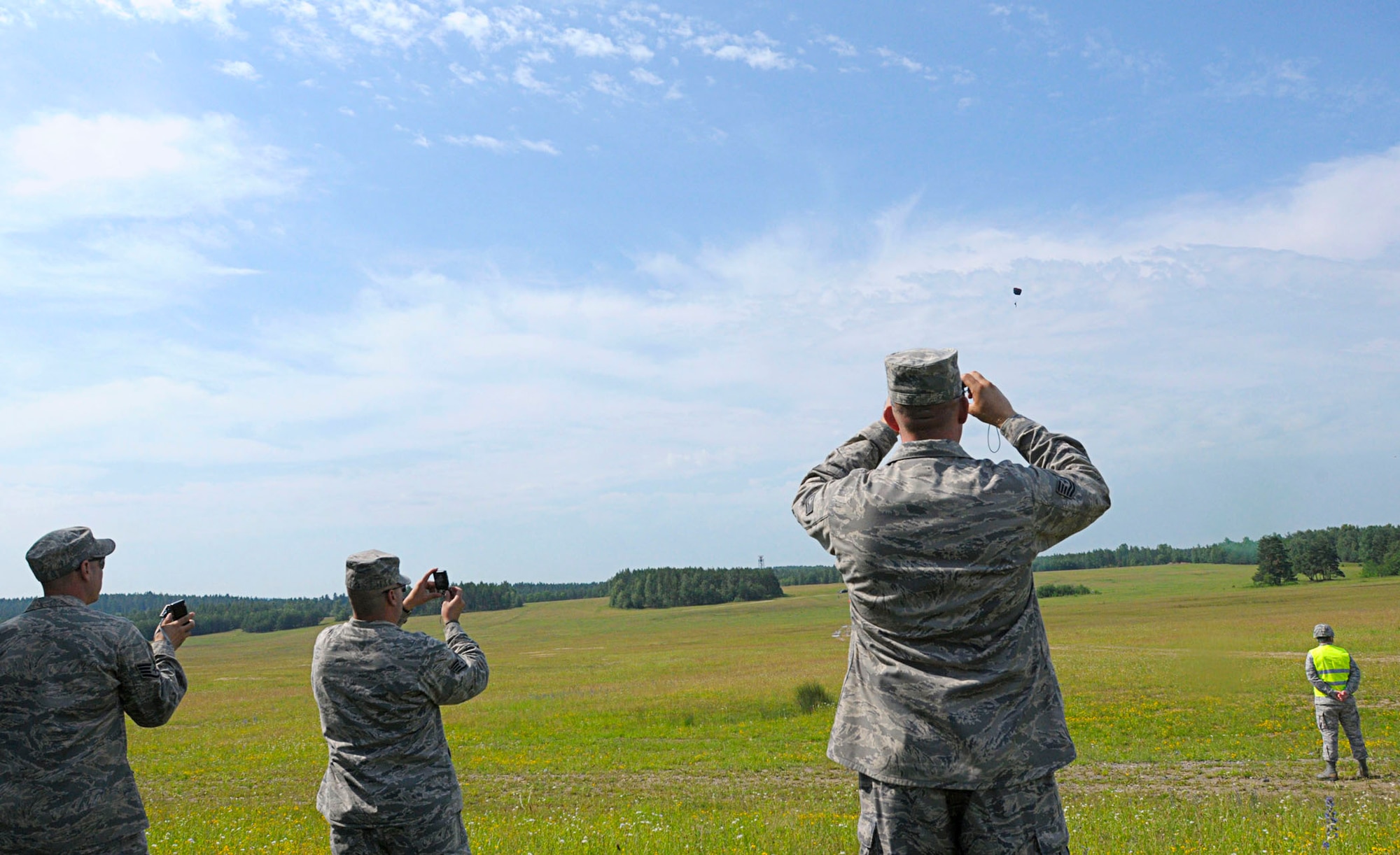 Airmen observe a high-altitude, low-opening  jump from a C-130J Super Hercules June 22, 2011, during the opening ceremony for Allied Strike 2011 at Grafenwoher Training Area, Germany. (U.S. Air Force photo/Airman 1st Class Desiree W. Esposito)