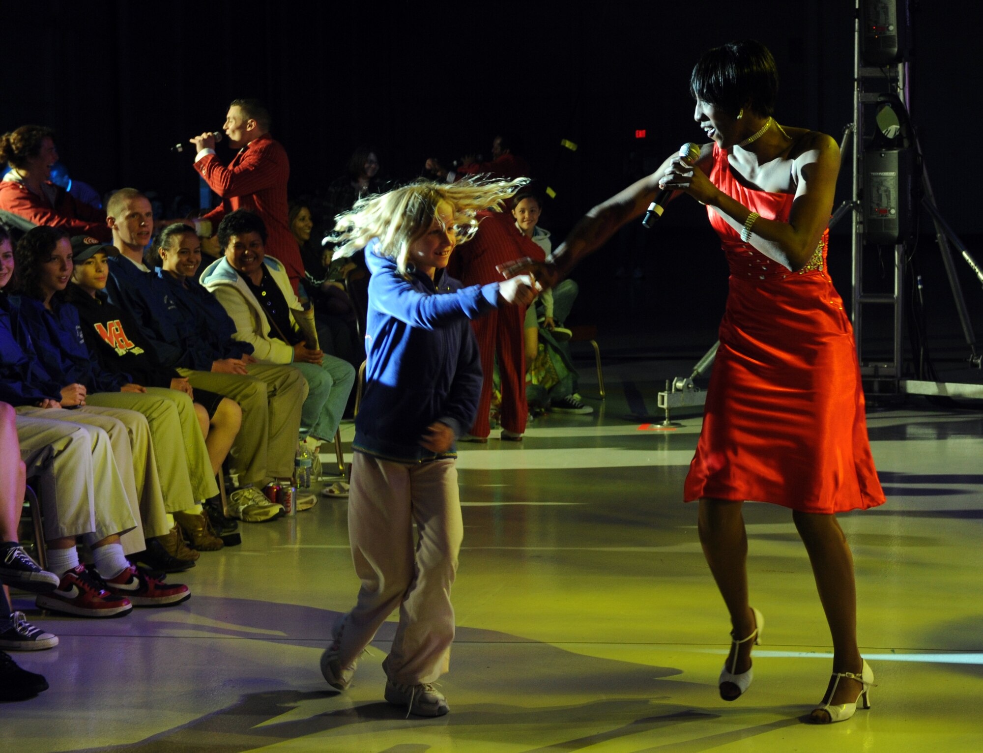 MOUNTAIN HOME AIR FORCE BASE, Idaho – Senior Airman Kristina Overton, 341st Missile Wing public affairs journeyman, dances with a member of the crowd during the Tops in Blue performance in hangar 1331, June 18. Tops in Blue is one of the oldest and most widely traveled entertainment groups of its kind and is composed of 35 to 40 talented vocalists, musicians, dancers and technicians. Their primary purpose is to perform for military personnel and their families throughout the world. (U.S. Air Force photo by Senior Airman Debbie Lockhart)