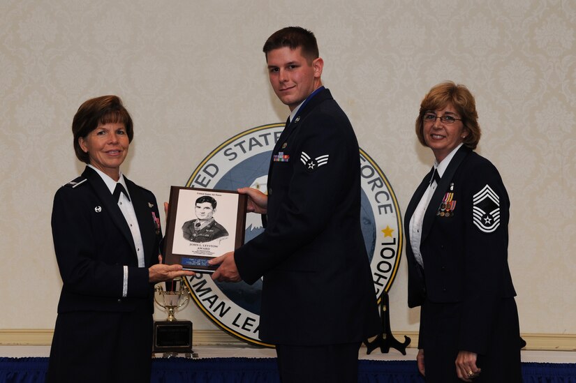 Col. Consuella Pocket and Chief Master Sgt. Stephanie Burroughs present Senior Airman Terry Coates the John Levitow award during the Airman Leadership School graduation June 23 at Joint Base Charleston - Air Base. The John Levitow award is presented to the Airman that displays the best overall performance evaluation, peer to staff rating and academic ranking while attending ALS, a six-week course designed to develop Airman into effective leaders and supervisors. Colonel Pockett is the 628th Medical Group Commander, Chief Burroughs is the 628th Medical Group superintendent and Airman Coates is with the 437th Aircraft Maintenance Squadron.  (U.S. Air Force Photo/ Staff Sgt. Nicole Mickle)  