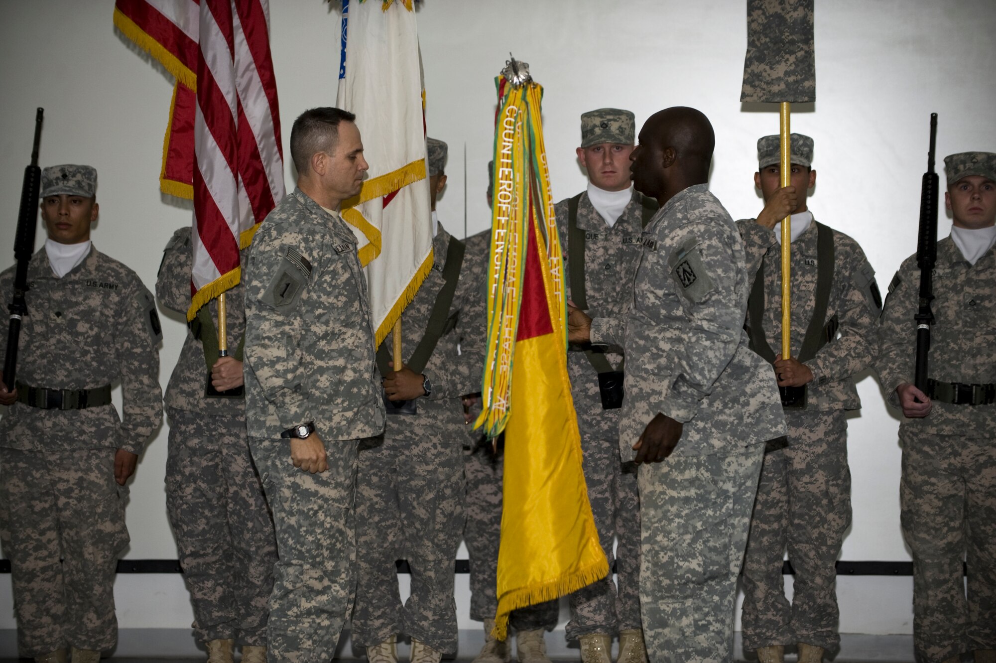 Col. Christopher L. Spillman, commander of the 108th Air Defense Artillery Brigade, and Command Sgt. Major Harold Lincoln, brigade command sergeant major of the 108th Air Defense Artillery Brigade, unfurl the brigade colors during a transition of authority ceremony, June 22, in Southwest Asia.  The 108th ADA replaced the 69th Air Defense Artillery Brigade as the command and control unit of air and missile defense forces in the Central Command area of responsibility. (U.S. Air Force Photo/Senior Airman Paul Labbe)