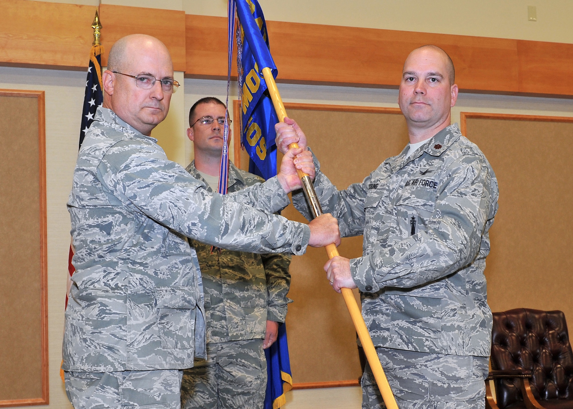 Maj. Brian Young accepts command of the 341st Maintenance Operations Squadron from Col. Jeffrey Frankhouser, 341st Maintenance Group commander, June 20 at the Grizzly Bend.  Master Sgt. Kenneth Williams 341st MOS first sergeant, looks on.  (U.S. Air Force photo/John Turner)