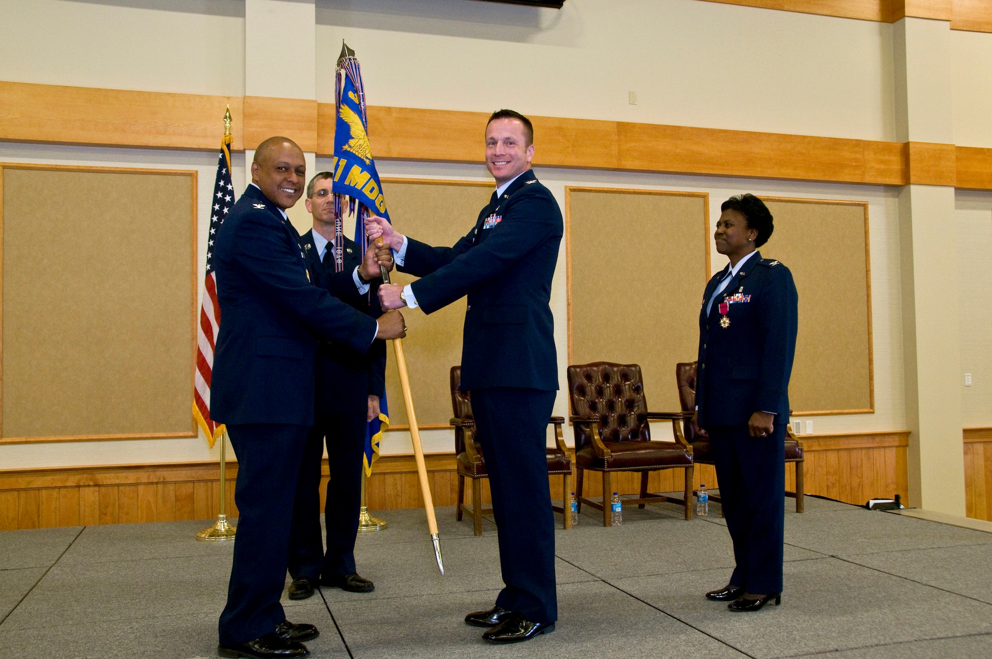 Col. R. Bruce Roehm accepts command of the 341st Medical Group from Brig. Gen. (Sel) Anthony Cotton, 341st Missile Wing commander, June 20 at the Grizzly Bend.  Col. Leslie L. Dixon, outgoing 341st MDG commander, and Chief Master Sgt. Duane Buchi, 341st MDG chief enlisted advisor, look on. (U.S. Air Force photo/John Turner)