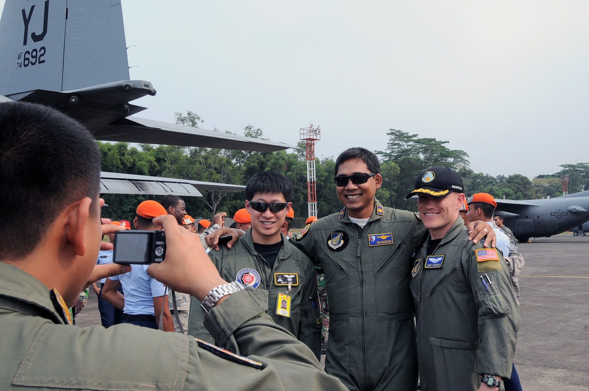 HALIM AIR BASE, Indonesia - Captains Matt Yan (left) and Andy Chapman (right), both pilots with the 36th Airlift Squadron from Yokota Air Base, Japan, pose for a photo with a fellow pilot from the Indonesian Air Force after exchanging patches following the closing ceremony for Exercise Cope West 11 here June 24, 2011. In addition to enhancing combined operating methods, the exercise also improved international relations between the U.S. and Indonesia. (U.S. Air Force photo/Capt. Raymond Geoffroy)