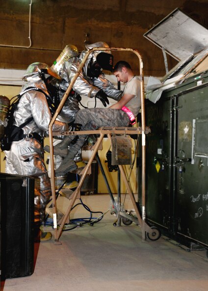 332nd Expeditionary Civil Engineering Squadron Fire Department firefighters simulate rescuing Airmen from a confined space June 18, 2011. The routine training offers the firefighters a chance to stay proficient in their skills.(U.S. Air Force photo by Senior Airman Jeffrey Schultze)