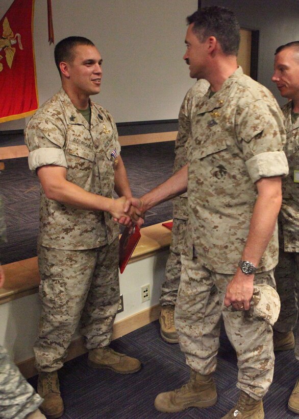 Navy Petty Officer First Class Amilcar Rodriguez, a corpsman previously assigned to 2d Marine Special Operations Battalion, U.S. Marine Corps Forces, Special Operations Command, shakes hands with a sailor after an awards ceremony at MARSOC Headquarters June 24, 2011, in which he was awarded the Silver Star for his extraordinary heroism while conducting combat operations in Bala Morghab, Afghanistan Nov. 6, 2009. The Silver Star is the nation's third-highest military decoration for valor in combat.