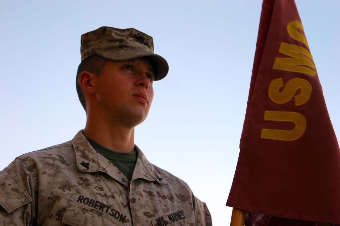 Lance Cpl. Patrick Robertson, a reserve infantry Marine from Houston, stands in front of his unit's, 1st Battalion, 23rd Marine Regiment, flag, while serving in Afghanistan. Robertson is currently going to college to get his degree in mechanical engineering and then potentially become a commissioned officer in the Marine Corps.