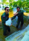 Burlington, N.D. -- 1st Lt. Devin Vitt(left) and Capt. Bryant Harrison, 23rd Bomb Squadron radar navigator and pilot respectively, help sandbag the home of Lt. Col. John Dawson, 5th Bomb Wing Inspector General, in Burlington, N.D. June 23, 2011. The Airmen are assigned to Minot Air Force Base, N.D. The Souris River, which begins in the Canadian province of Saskatchewan, is expected to inundate thousands of homes and businesses. (U.S. Air Force photo by Staff Sharida Jackson) (RELEASED)
