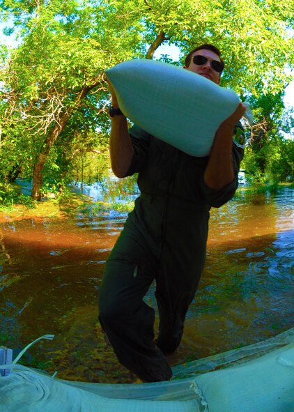 Burlington, N.D. -- Radar navigator 1st Lt. Devin Vitt, from the 23rd Bomb Squadron, Minot Air Force Base, N.D., helps sandbag the home of Lt. Col. John Dawson, 5th Bomb Wing Inspector General, in Burlington, N.D. June 23, 2011. The Souris River, which begins in the Canadian province of Saskatchewan, is expected to inundate thousands of homes and businesses. (U.S. Air Force photo by Staff Sharida Jackson) (RELEASED)