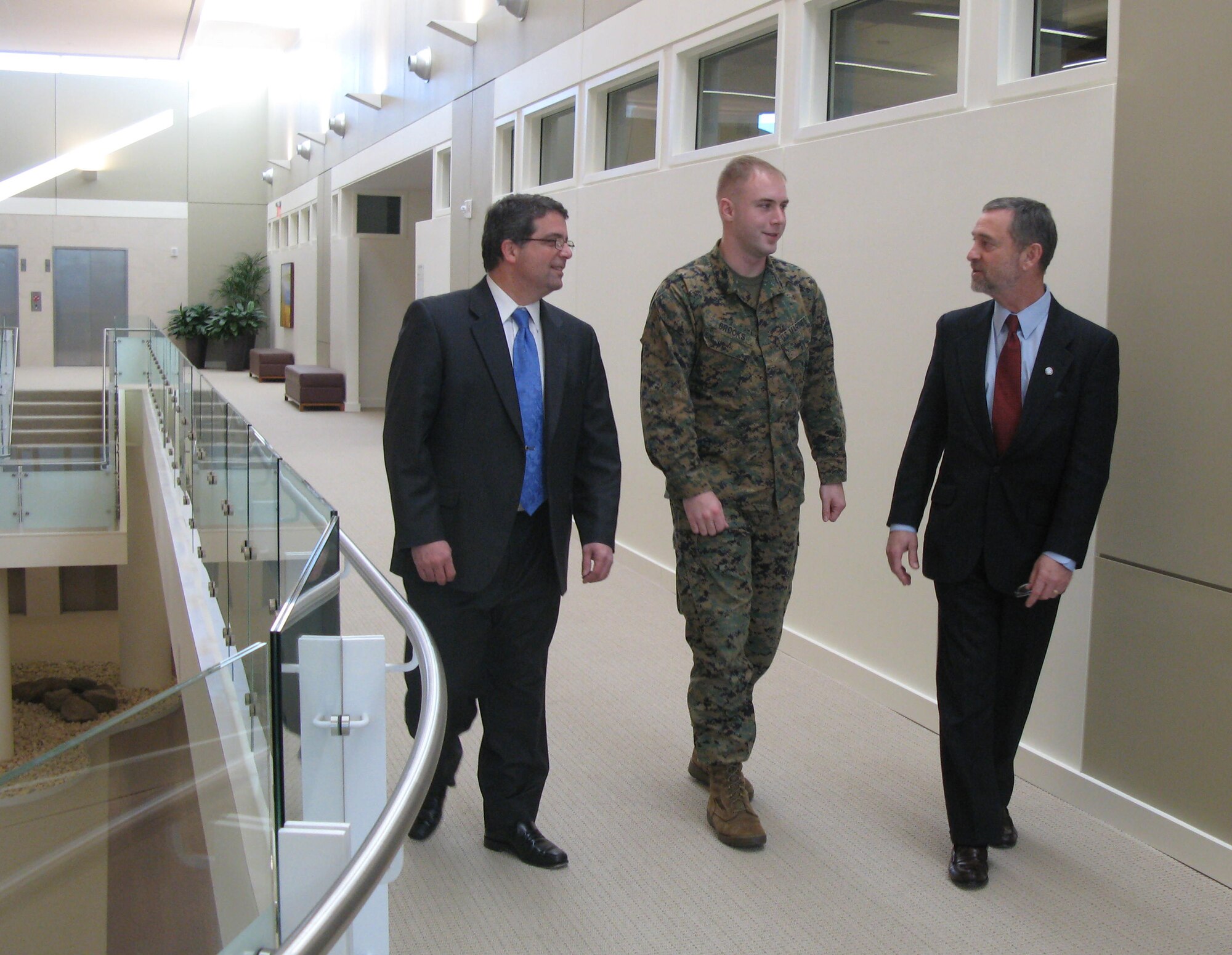 Marine Corps Sgt. Tim Brooks, a former patient at the National Intrepid Center of Excellence in Bethesda, Md., chats with Dr. James Kelly, right, the center’s director, and Dr. Thomas J. DeGraba, its deputy director, about the comprehensive, holistic treatment provided at the center. Sergeant Brooks suffered a traumatic brain injury after being exposed to a rocket attack and three roadside bomb attacks in Iraq. (Defense Department photo/Donna Miles)