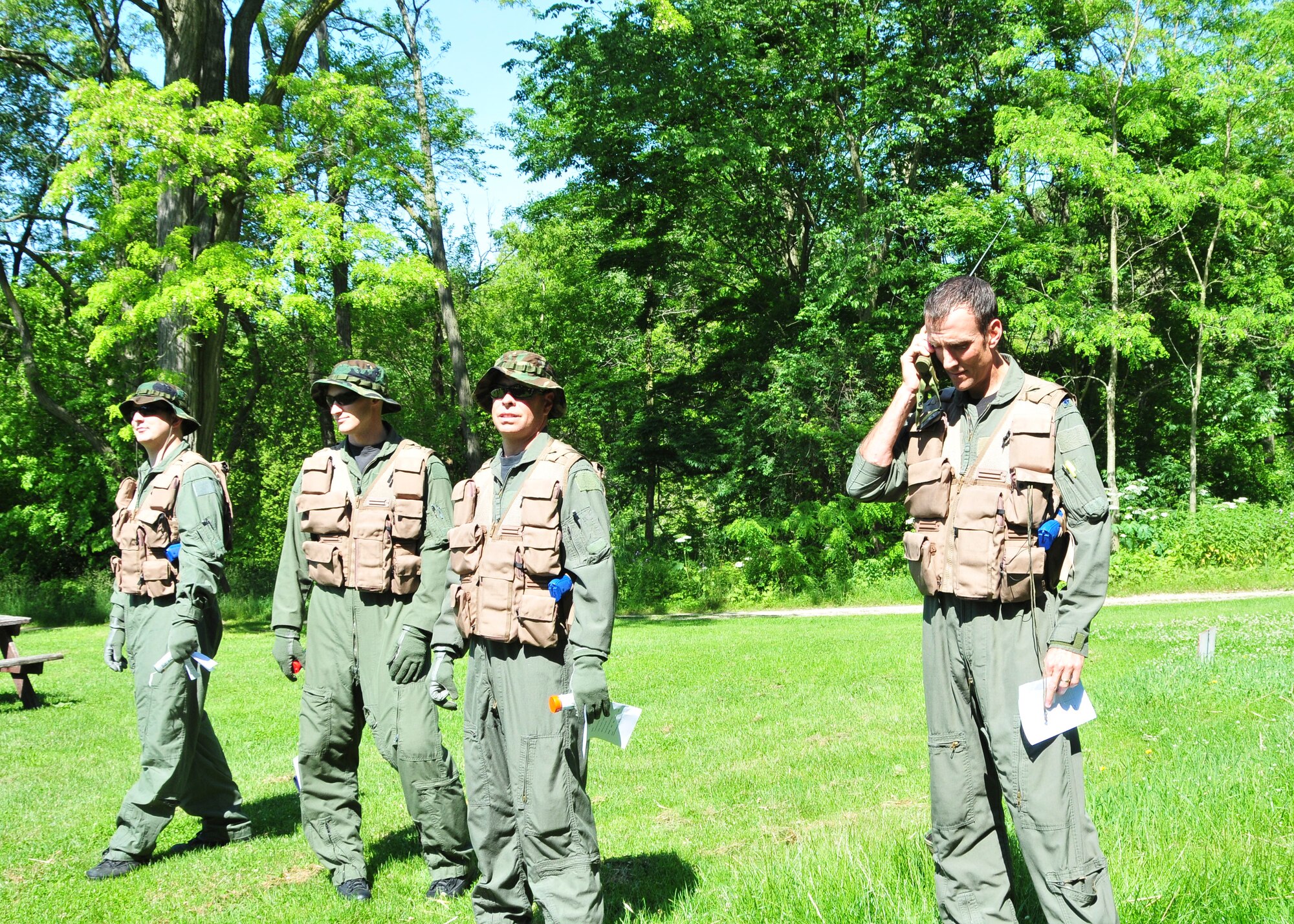 MILWAUKEE--Airmen from the 128th Air Refueling Wing Operations Squadron's aircrew await the arrival of a U.S. Coast Guard HH-65 Dolphin as grid coordinates are called in via hand-held radio on Saturday, June 25, 2011.  The Operations Squadron's aircrew took part in a one-day annual training event that refreshed survival techniques, which are taught to all Air Force aircrew members.  (U.S. Air Force photo by Master Sgt. Kenneth Pagel / Released)