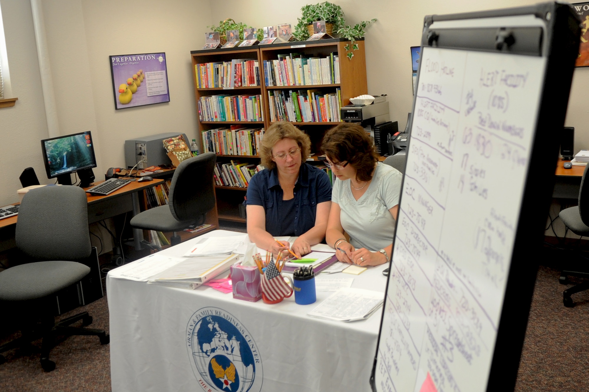 MINOT AIR FORCE BASE, N.D. -- Terri Stansell, 5th Maintenance Group key spouse mentor, and Michelle VanBemmelen, 5th Operations Group key spouse mentor, discuss procedures for logging volunteer information here at the Emergency Family Assistance Control Center June 25. Both Mrs. Stansell and Mrs. VanBemmelen have volunteered as much as they can to help manage the EFACC’s 24-hour operations in support of base personnel affected by the flooding situation in Minot. (U.S. Air Force photo/Airman 1st Class Jose L. Hernandez)

 

