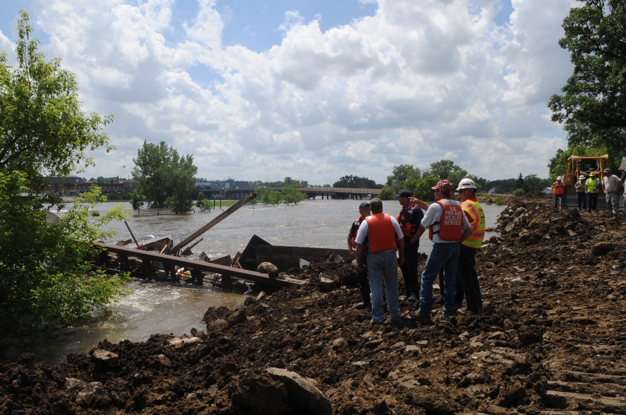 MINOT, N.D. -- City workers and the North Dakota National Guard, are discussing ways to handle the possible detachment of the pedestrian bridge here June 25. The bridge has been blocking debris flowing downriver, causing the actual bridge to move. Soldiers and Airmen are standing by with equipment to pull the bridge out of the water should it detach. (U.S. Air Force photo/ Capt. Genieve David)