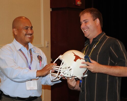 AUSTIN, Texas—Adrian Caballero, right, a munitions craftsman at Homestead Air Reserve Base, Fla., wins a Texas Longhorns football helmet at the Air Force Reserve Command’s South Region Yellow Ribbon Program in Austin June 25. He won the helmet as an end-of-day prize. (U.S. Air Force photo/Staff Sgt. Anna-Marie Wyant)