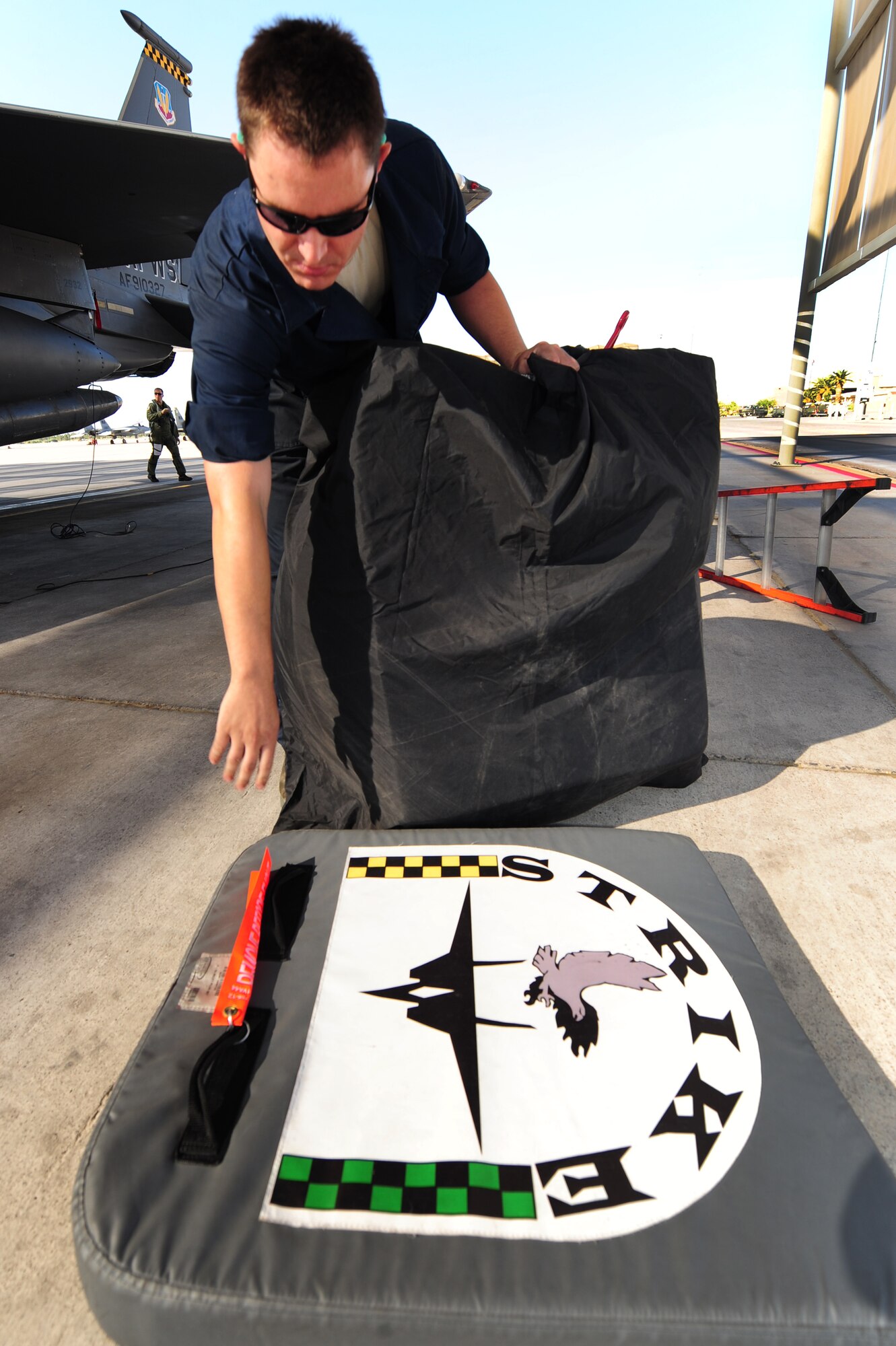 Airman 1st Class Adam Crough, 757th Aircraft Maintenance Squadron crew chief, stows the intake covers from an F-15 Eagle at Nellis Air Force Base, Nev., June 14, 2011.  Airmen from the 757th Aircraft Maintenance Squadron accomplish intermediate-level maintenance on aircraft and support equipment components, maintaining avionics, laser guided weapons systems, pneudraulics, fuel systems, engines, measurement/diagnostic equipment, electro-environmental, and egress systems.  (U.S. Air Force photo by Staff Sgt. William P.Coleman)
  

