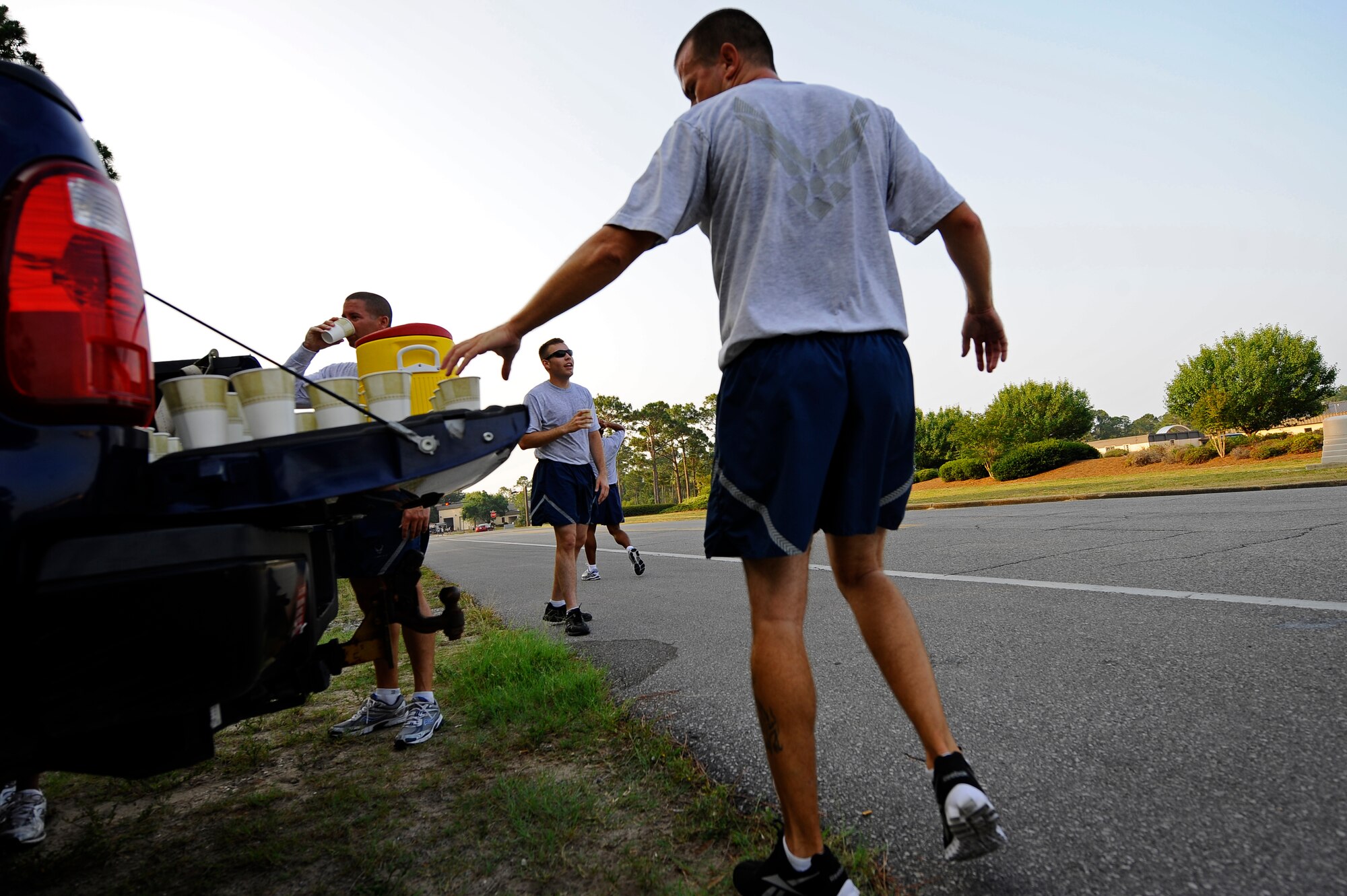 Members of the 823rd RED HORSE Squadron drink water after a run during physical training, Hurlburt Field, Fla., June 13, 2011. The 823rd RHS set up a water station at the end of the running course to encourage proper hydration and reduce the likelihood of heat-related injuries. (U.S. Air Force photo by Staff Sgt. Julianne M. Showalter)
