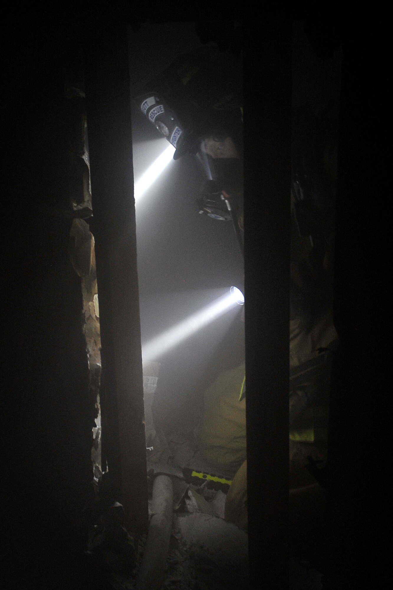 Jimmy Liptrott, firefighter with the 55th Civil Engineering Squadron, looks at his instruments before squeezing through a wall inside Bldg 163 on Offutt Air Force Base, Neb., during the Surviving the Fire Ground, Fire Fighter/Fire Officer and Command Preparedness exercise June 23. This was an international event and titled Fire/EMS Safety, Health and Survival Week sponsored by the International Association of Fire Chiefs and the International Association of Firefighters. This event strengthens the awareness for proper procedures assisting a firefighter in need. 

U.S. Air Force Photo by Charles Haymond/Released