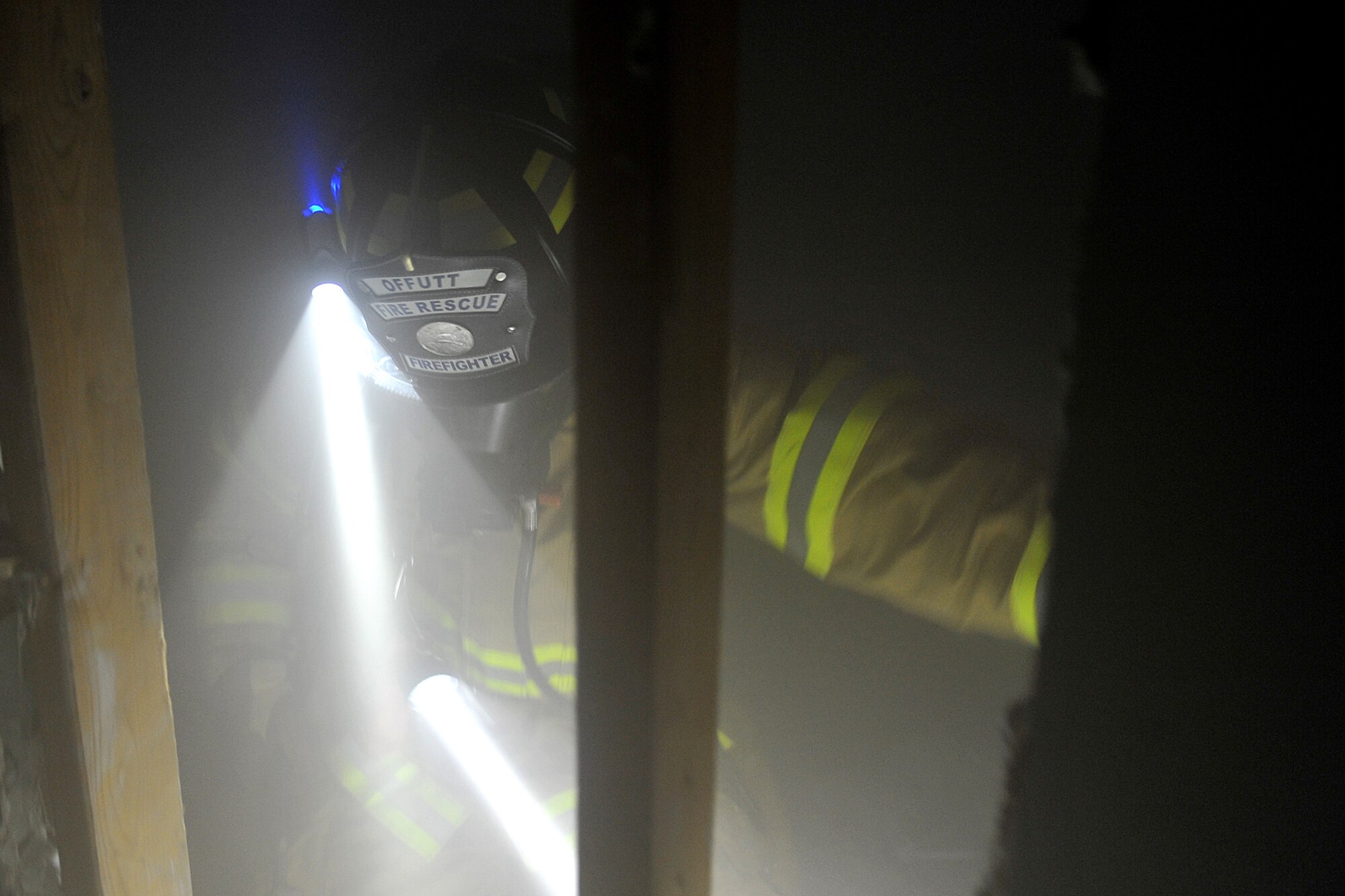 Jimmy Liptrott, firefighter with the 55th Civil Engineering Squadron, prepares to squeeze through a wall inside Bldg 163 on Offutt Air Force Base, Neb., during the Surviving the Fire Ground, Fire Fighter/Fire Officer and Command Preparedness exercise June 23. This was an international event and titled Fire/EMS Safety, Health and Survival Week sponsored by the International Association of Fire Chiefs and the International Association of Firefighters. This event strengthens the awareness for proper procedures assisting a firefighter in need. 

U.S. Air Force Photo by Charles Haymond/Released 