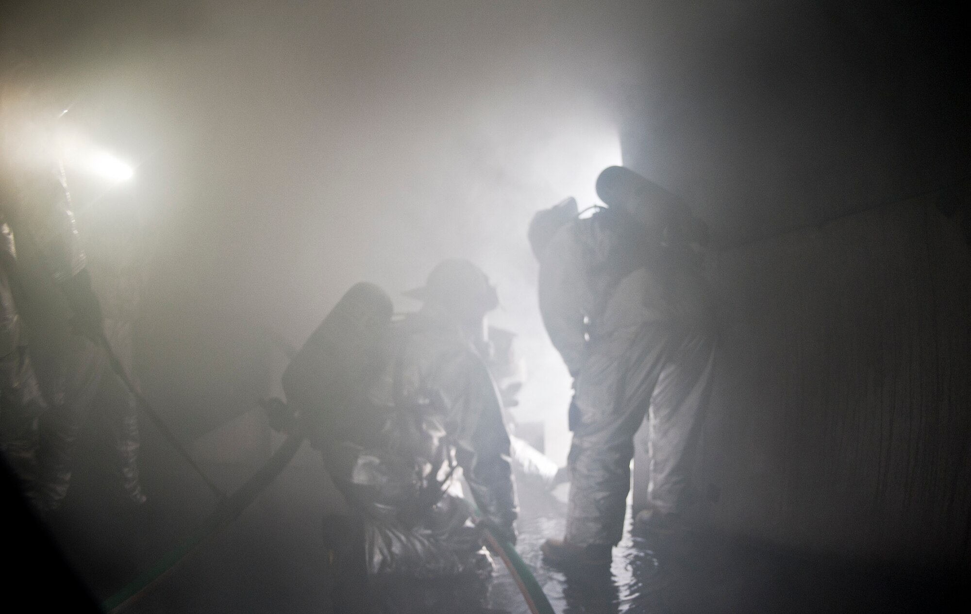 Members of the 23rd Civil Engineer Squadron fire department use their hoses to ventilate a room after extinguishing a fire during training at Moody Air Force Base, Ga., June 24, 2011. The firefighters used water pressure to push out the smoke and clear the room. (U.S. Air Force photo by Airman 1st Class Nicholas Benroth/Released)