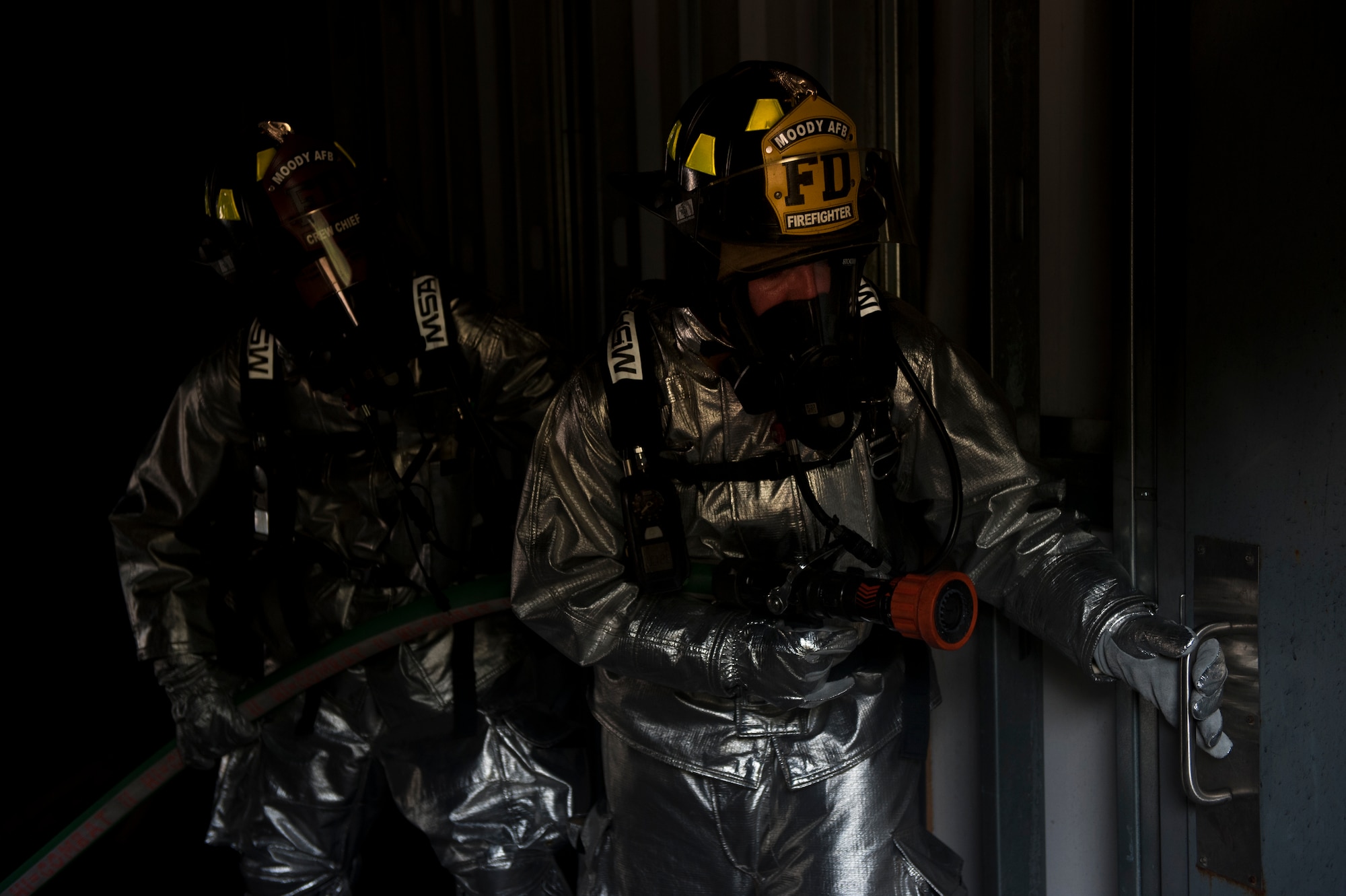 U.S. Air Force Staff Sgt. Nicholas Schnoes, 23rd Civil Engineer Squadron crew chief, supports another firefighter as they prepare to enter a room with a temperature of nearly 1,000 degrees Celsius during training at Moody Air Force Base, Ga., June 24, 2011. As the first team in tried to suppress the fire with a direct hit, a second team stayed behind to provide support if needed.
(U.S. Air Force photo by Airman 1st Class Nicholas Benroth/Released)