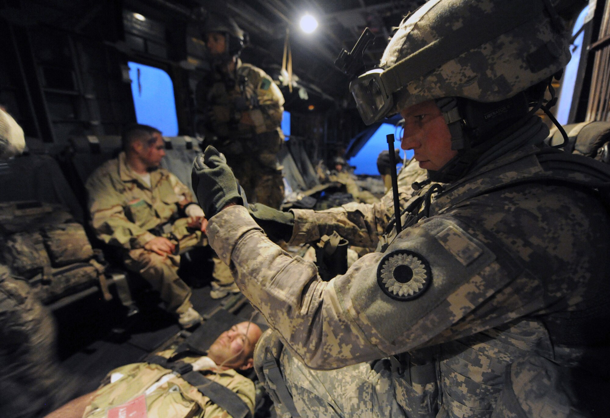 Army Sergeant Michael Stine, 1st Battalion, 161st Field Artillery, holds an IV bag for a “victim” of a simulated aircraft crash June 16, 2011, during a personnel recovery exercise.  Air Force pararescuemen and Army Soldiers extracted six “casualties” from the Grand Bara Desert in Djibouti, performing lifesaving medical procedures aboard Marine Corps MH-53 Pave Low helicopters transporting them to back Camp Lemonnier, Djibouti.  The scenario was part of a joint training exercise involving all branches of the U.S. military stationed at Camp Lemonnier. (U.S. Air Force photo/Staff Sgt. Austin M. May)