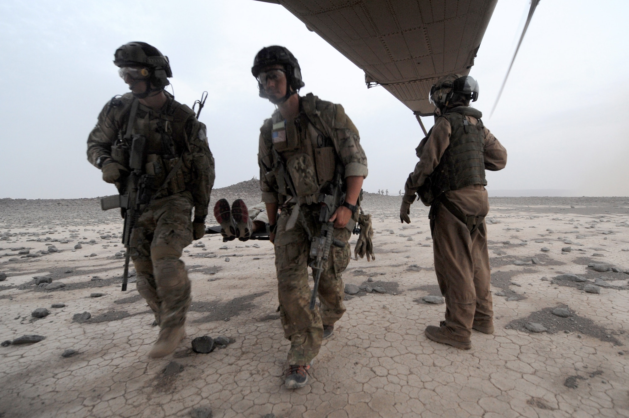 Air Force pararescuemen carry a “victim” of a simulated aircraft crash in the Grand Bara Desert in Djibouti onto a Marine Corps MH-53 Pave Low helicopter June 16, 2011, during a personnel recovery exercise.  The scenario was part of a joint training exercise involving all branches of the U.S. military stationed at Camp Lemonnier, Djibouti. (U.S. Air Force photo/Staff Sgt. Austin M. May)