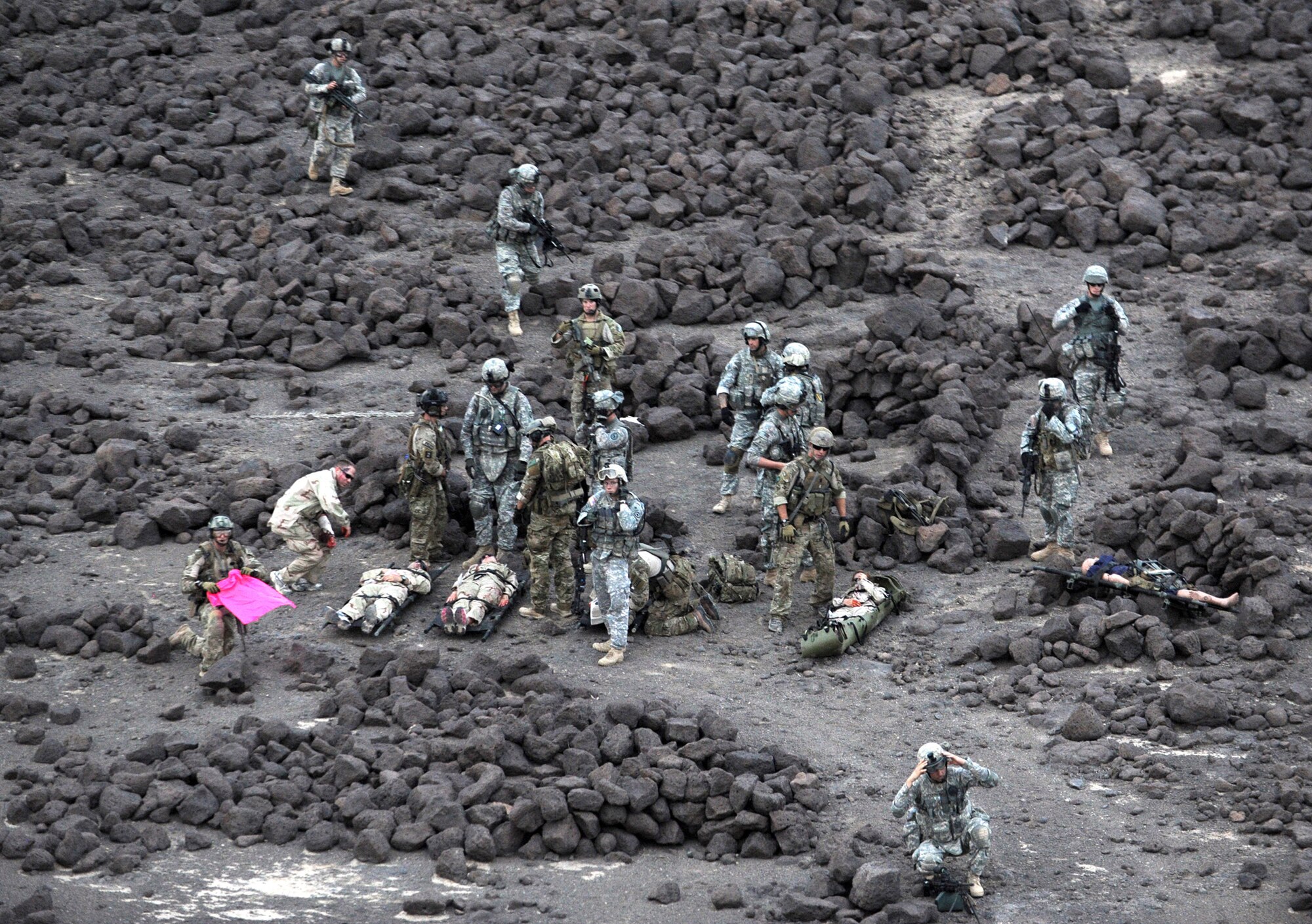 A group of Air Force pararescuemen, Army site security team members and “victims” of a simulated aircraft crash wait in the Grand Bara Desert in Djibouti for the arrival of a U.S. Marine Corps MH-53 Pave Low helicopter June 16, 2011.  The scenario was part of a joint training exercise involving all branches of the U.S. military stationed at Camp Lemonnier, Djibouti. (U.S. Air Force photo/Staff Sgt. Austin M. May)